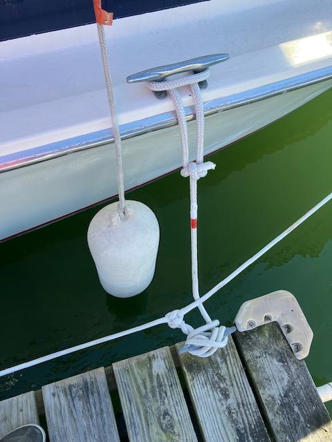 1974 Bertram 28 Flybridge docked with fender and rope, wooden pier visible.