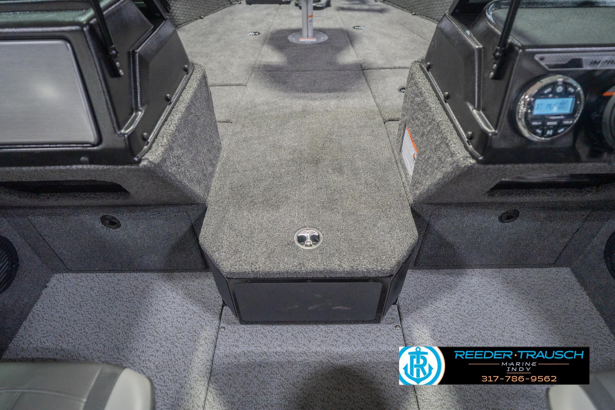 Interior of 2026 Lund 2075 Impact XS boat, featuring carpeted flooring and control panel.