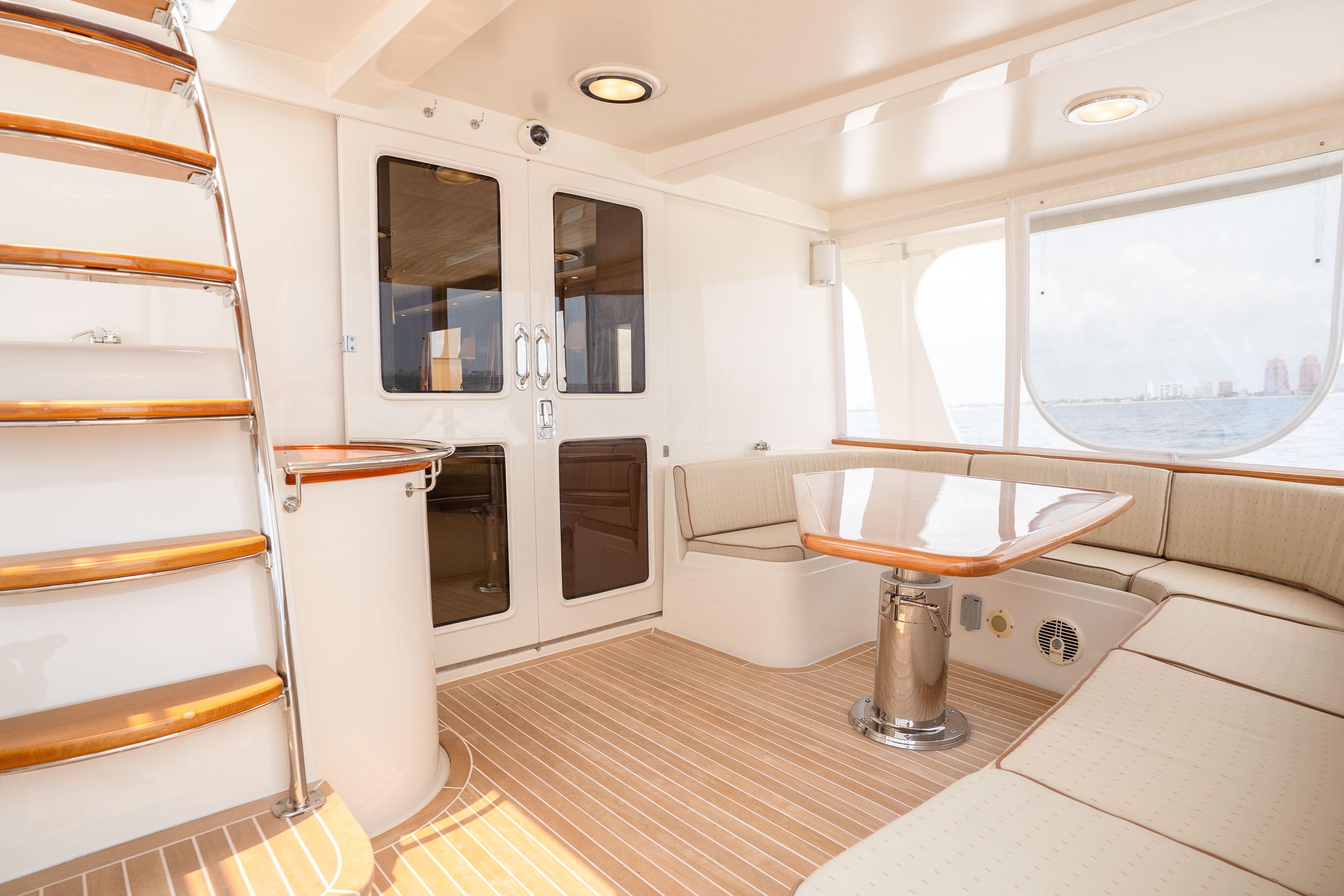 Luxurious interior of 2006 Fleming 75 yacht with elegant seating and wooden accents.