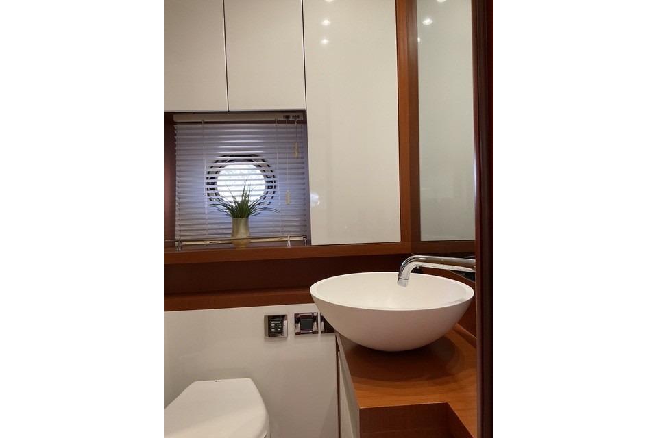 Bathroom interior of 2014 Beneteau Gran Turismo 49 yacht with modern sink and porthole window.
