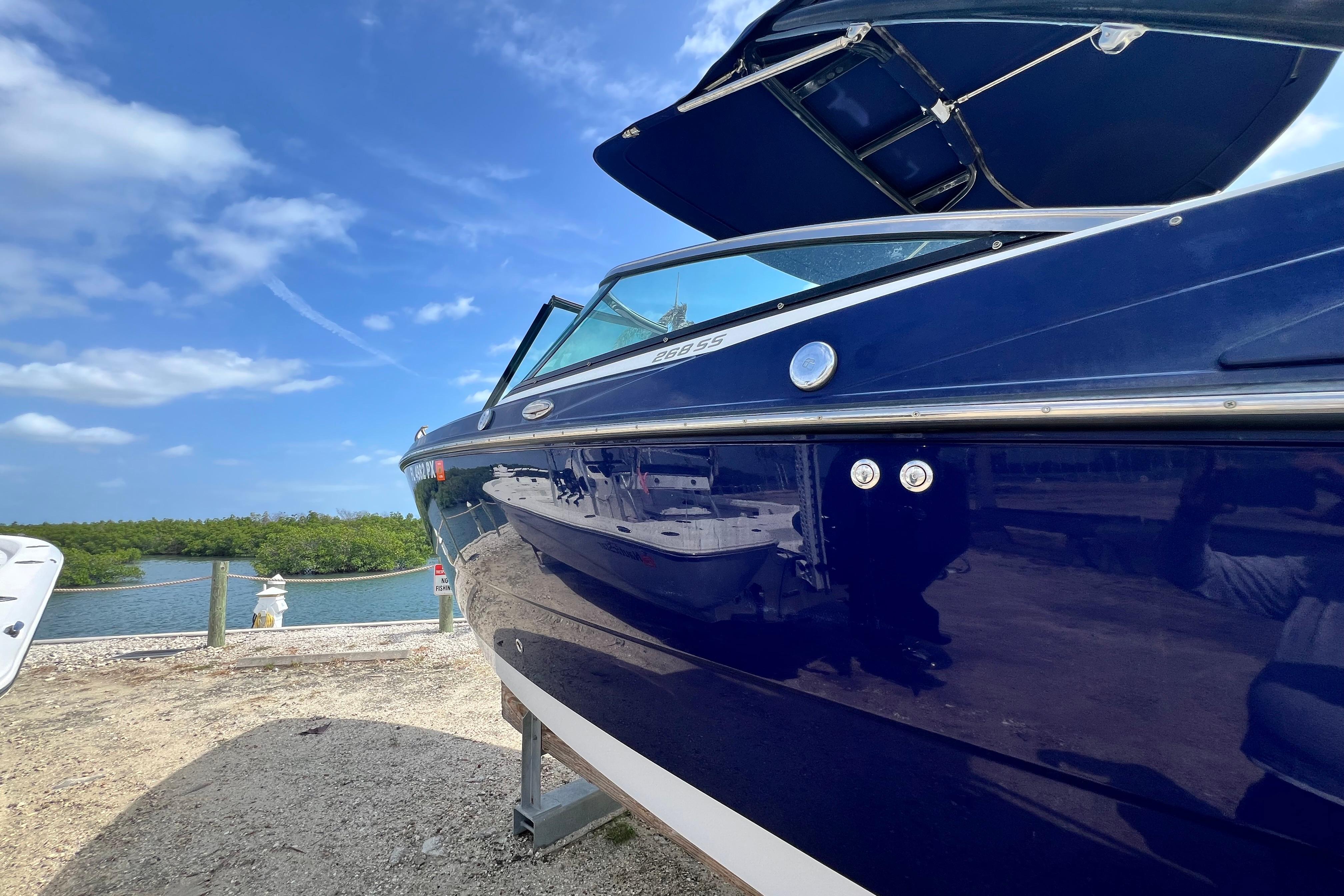 2015 Monterey 268SS Super Sport boat docked by a scenic waterfront.