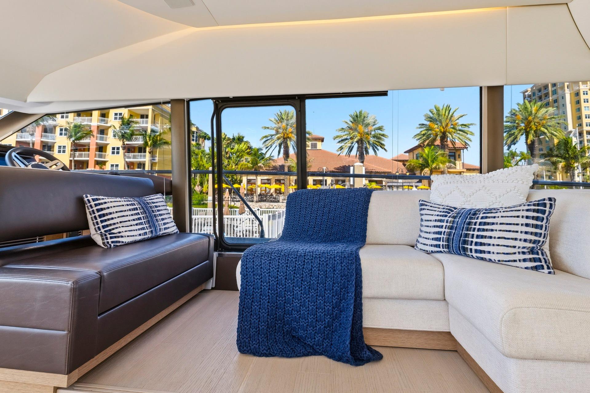 Luxurious interior of 2022 Prestige 520 yacht with elegant seating and scenic view.