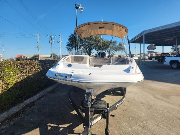 2025 Tahoe 1950 boat with canopy on trailer, parked outdoors under clear blue sky.