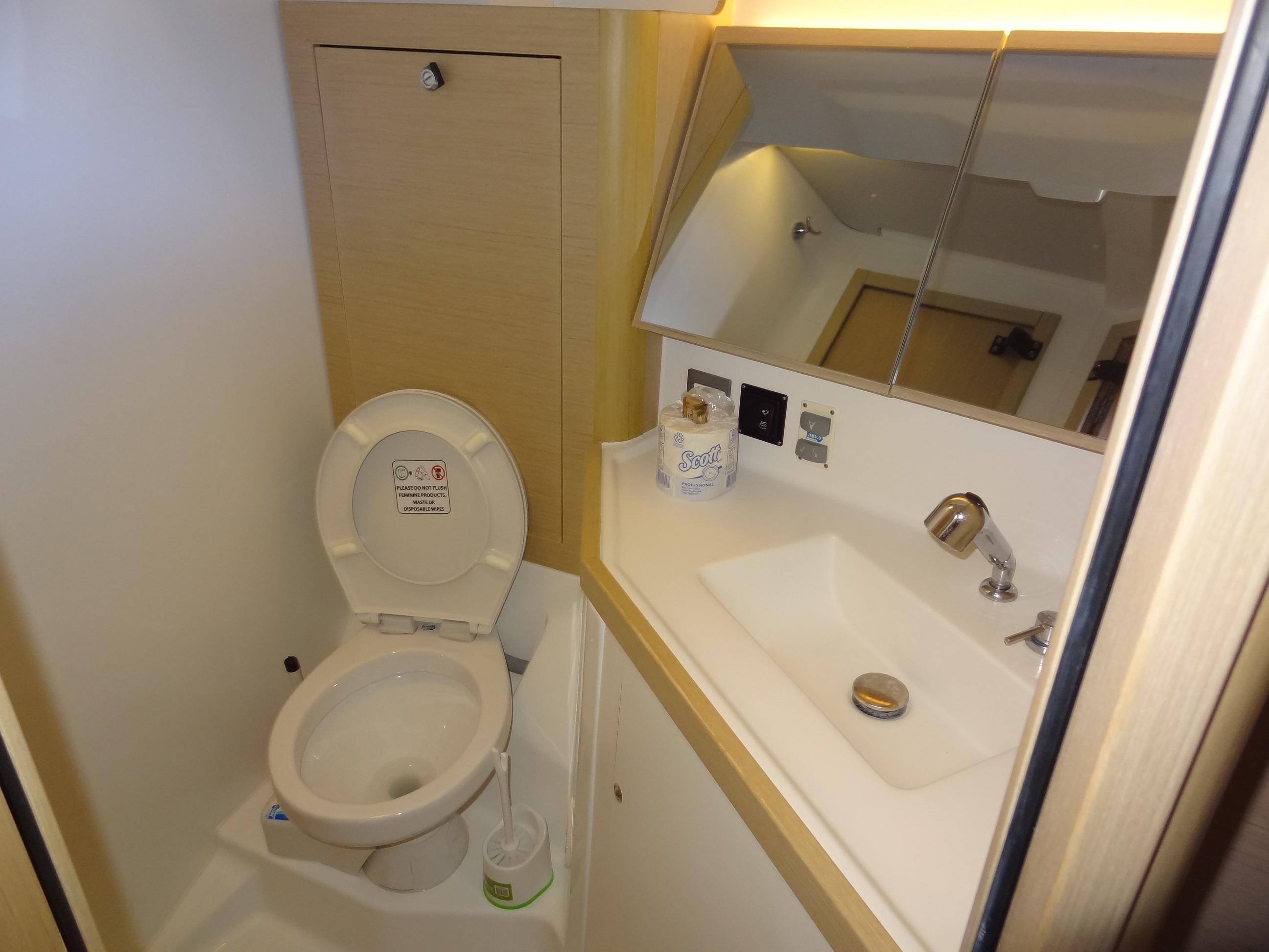 Beneteau Oceanis 46.1 2020 bathroom with toilet, sink, and mirror.