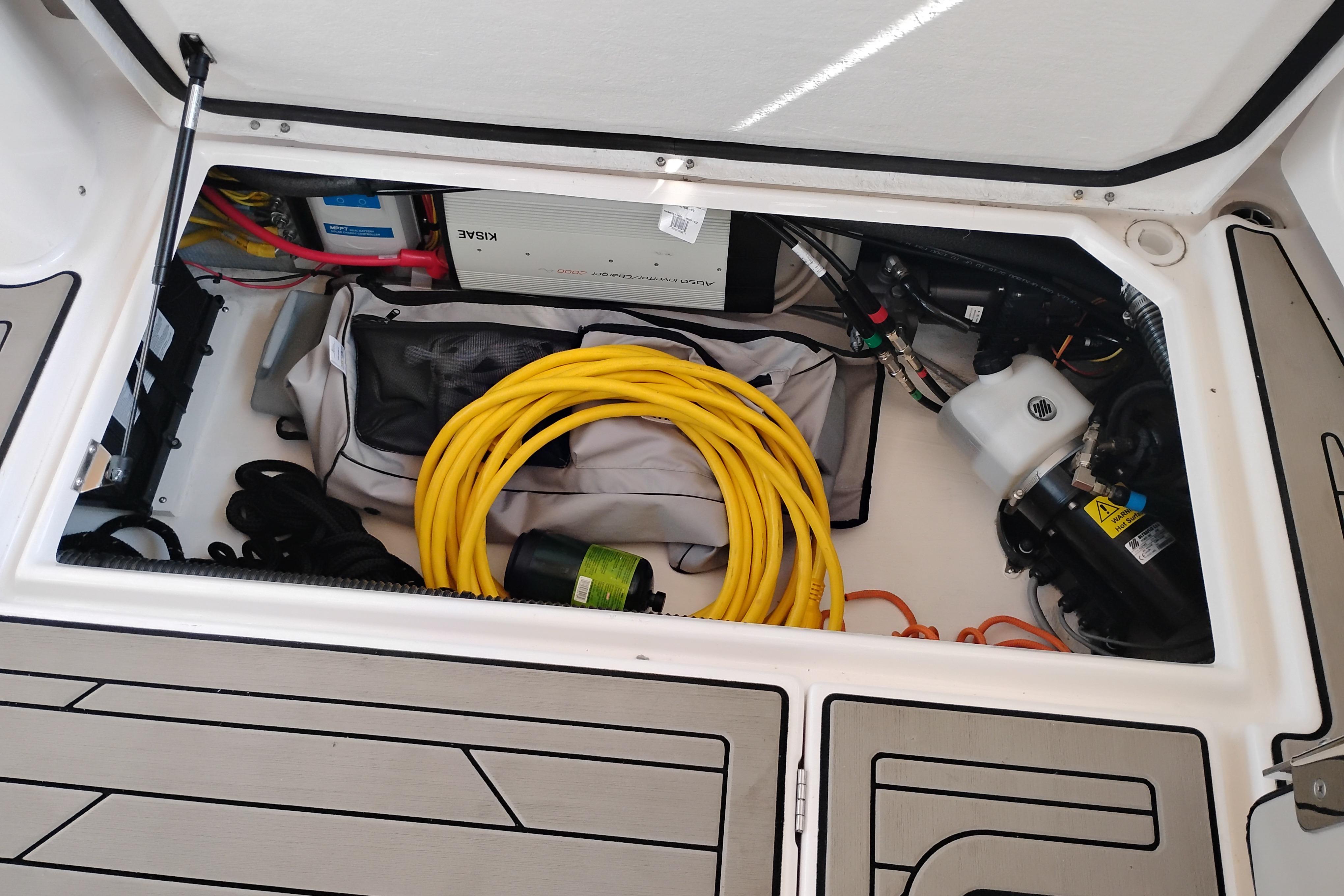 Storage compartment of 2022 Cutwater C-32 Coupe with cables and equipment.