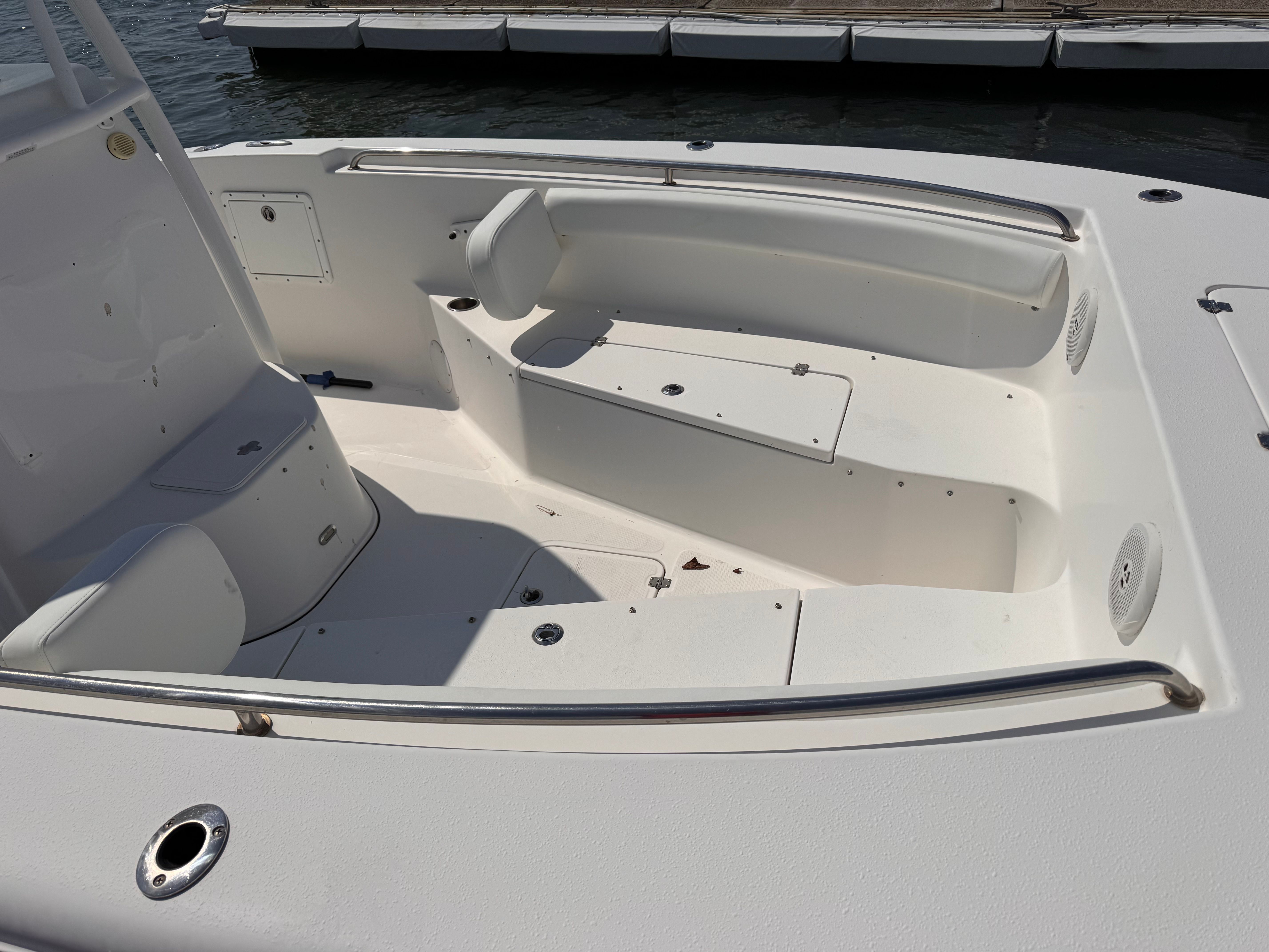 The image shows the cockpit of a 2015 Tidewater 250 Adventure boat. It features white seating and stainless steel railings.