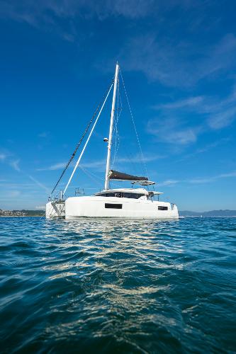 2025 Lagoon 43 catamaran sailing on calm blue waters under clear skies.