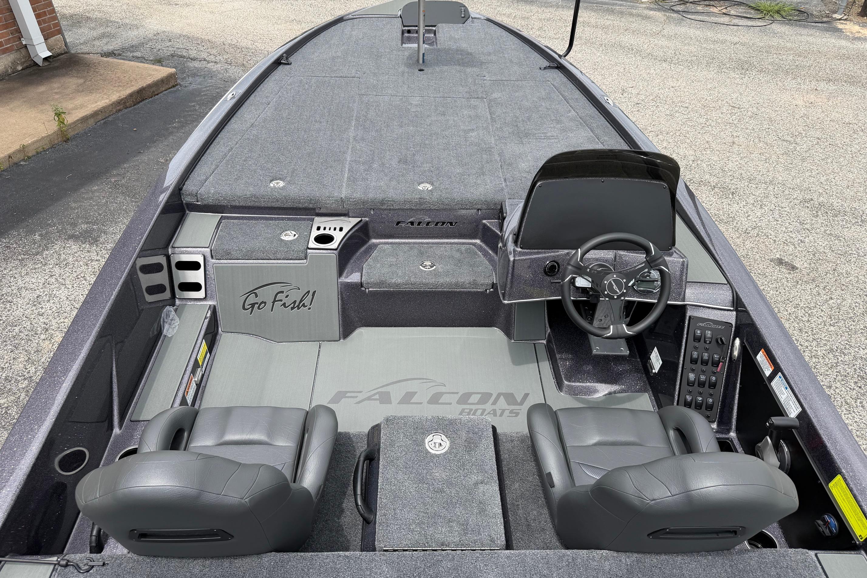 2027 Falcon Boats F215 interior with steering wheel, seats, and "Go Fish!" storage compartment.