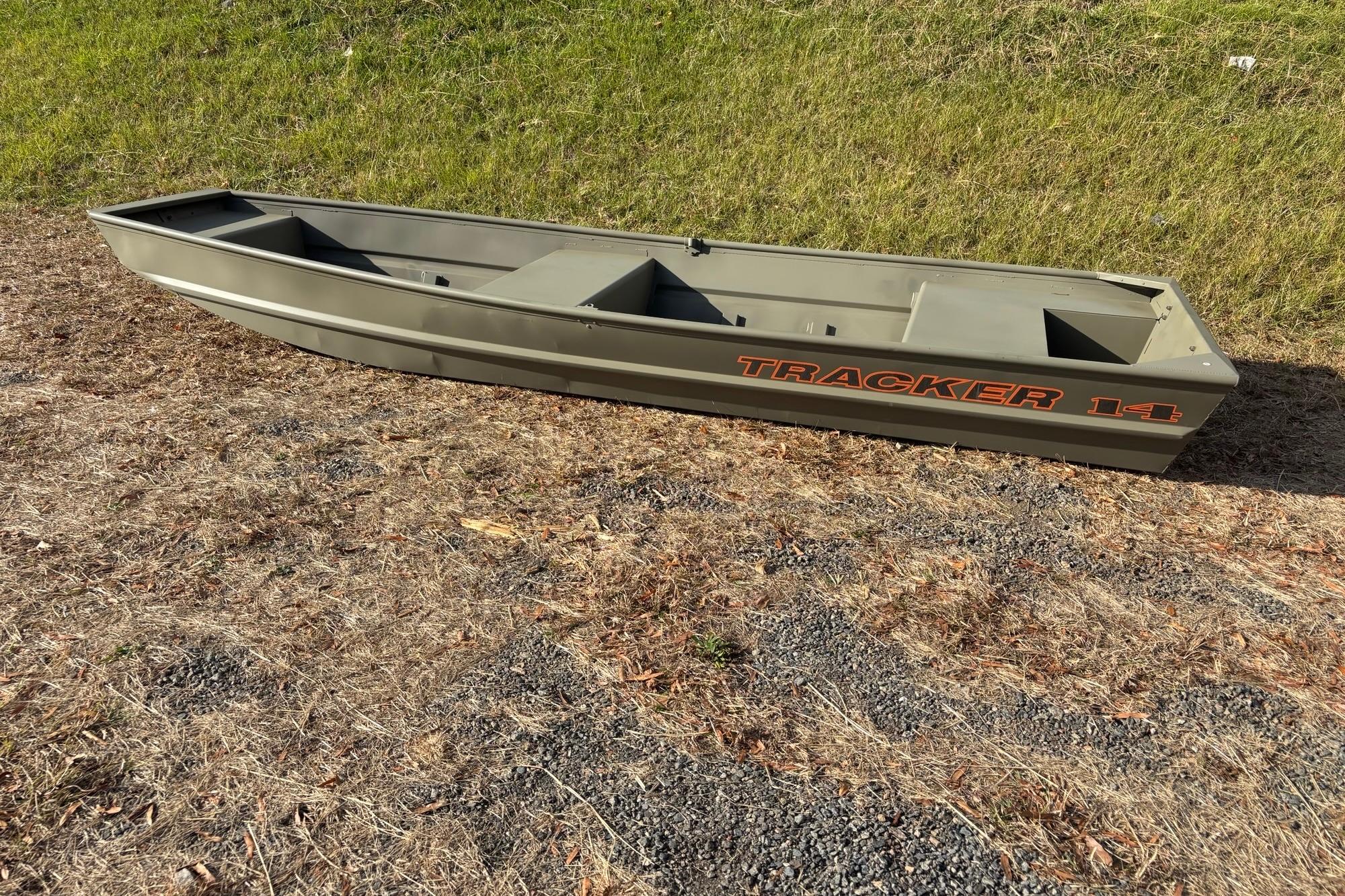 2026 Tracker Grizzly 14 Jon boat on dry grass, showcasing its sturdy design.