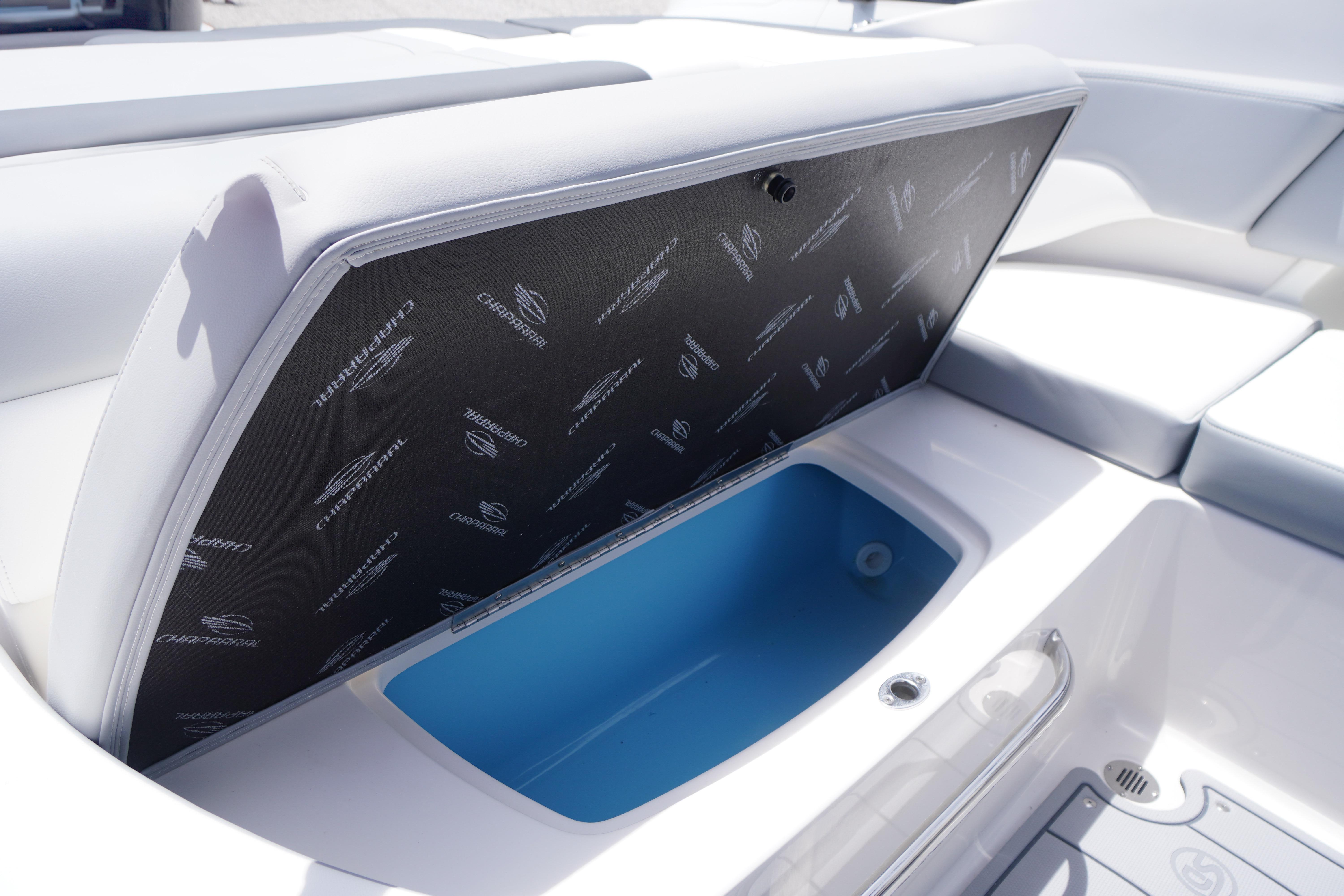 2026 Chaparral 23 SSi OB boat storage compartment with cushioned seating and blue interior.