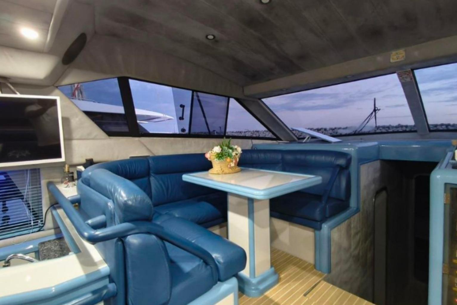 Luxurious interior of 1991 Dalla Pieta 52 Asterion yacht with blue seating and dining area.