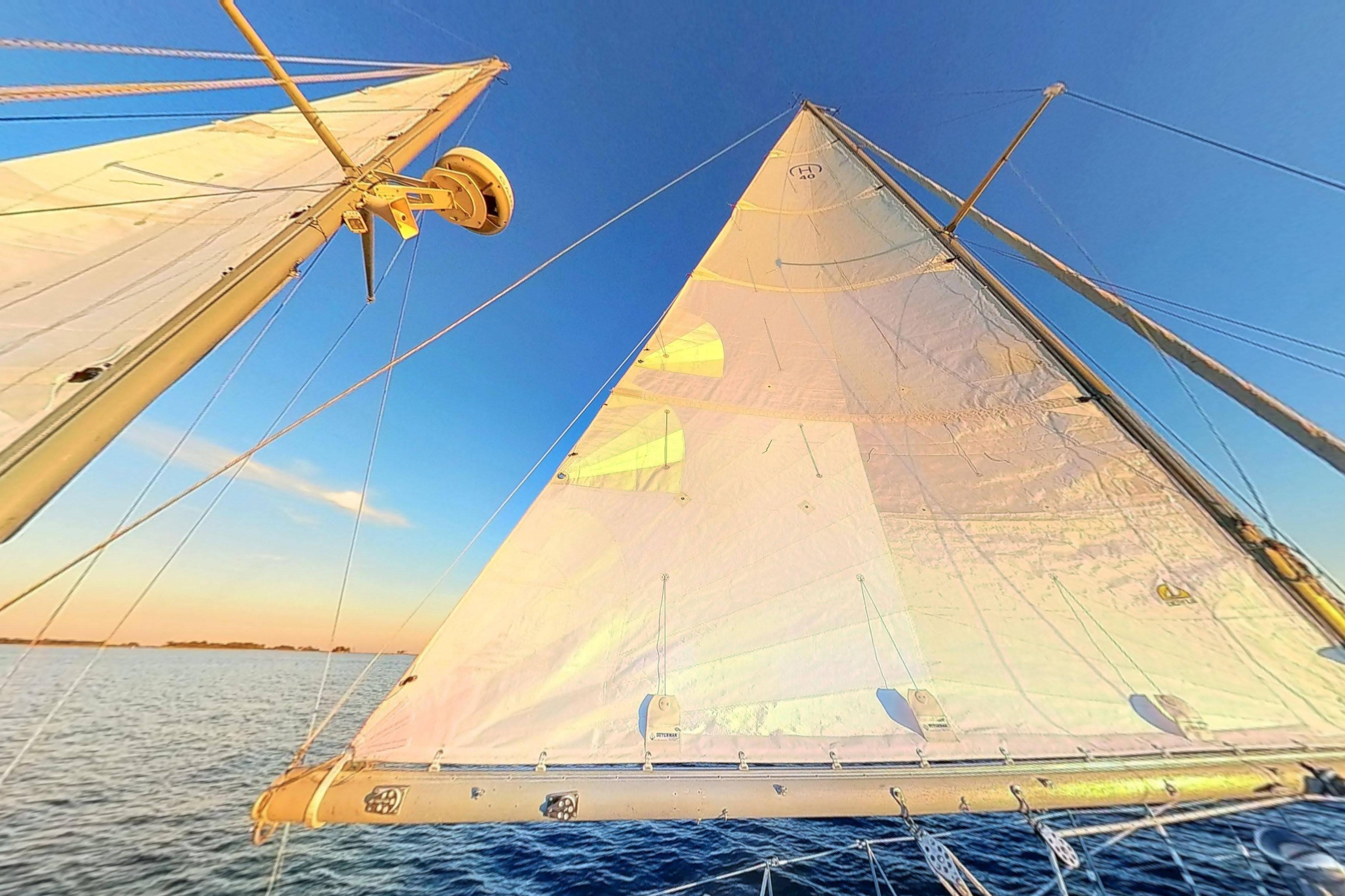 Sailing on a 1970 Hinckley Bermuda 40, vibrant sails against a clear blue sky.