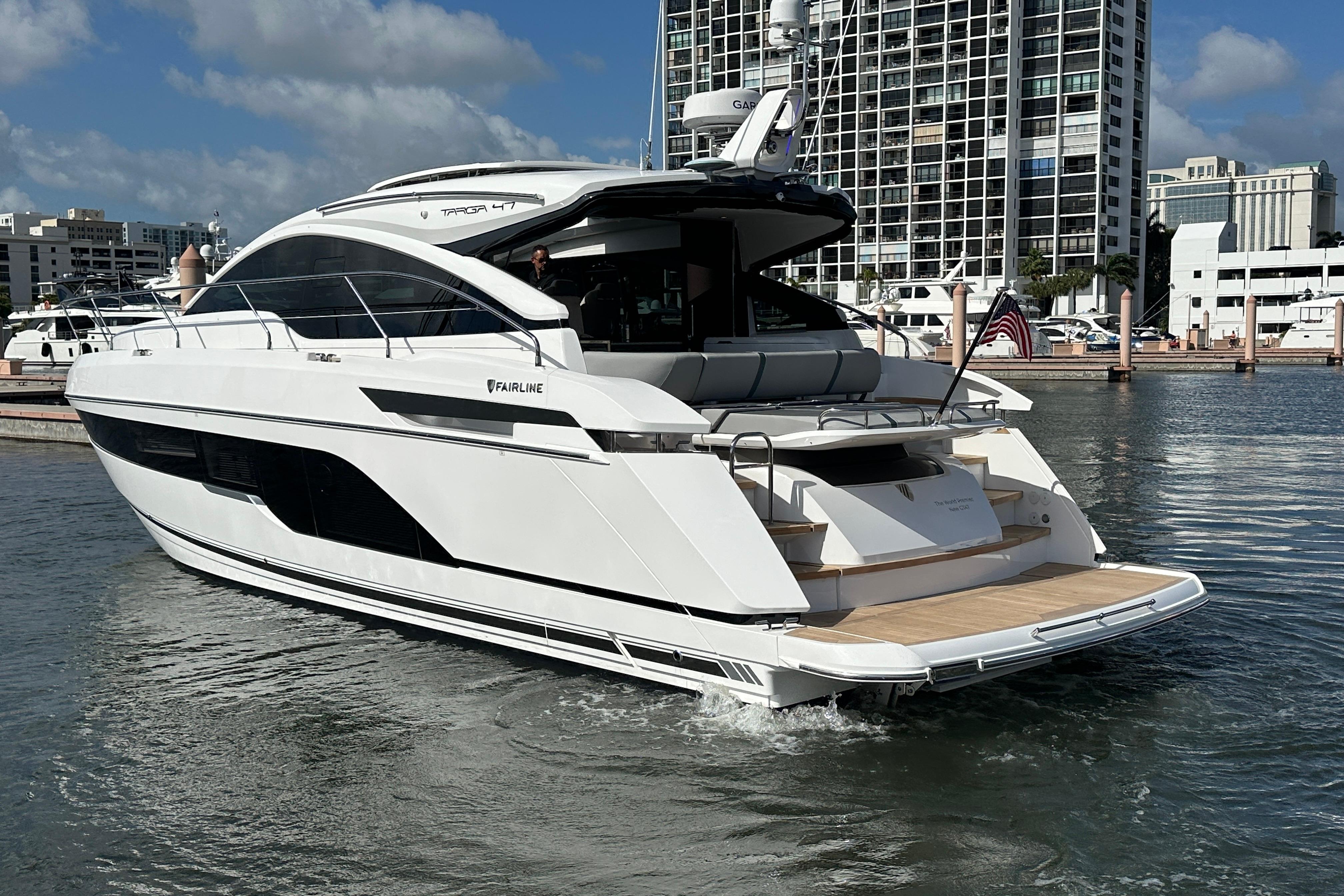 Luxury Fairline Targa 47 GT yacht, 2026 model, docked in a marina with cityscape backdrop.