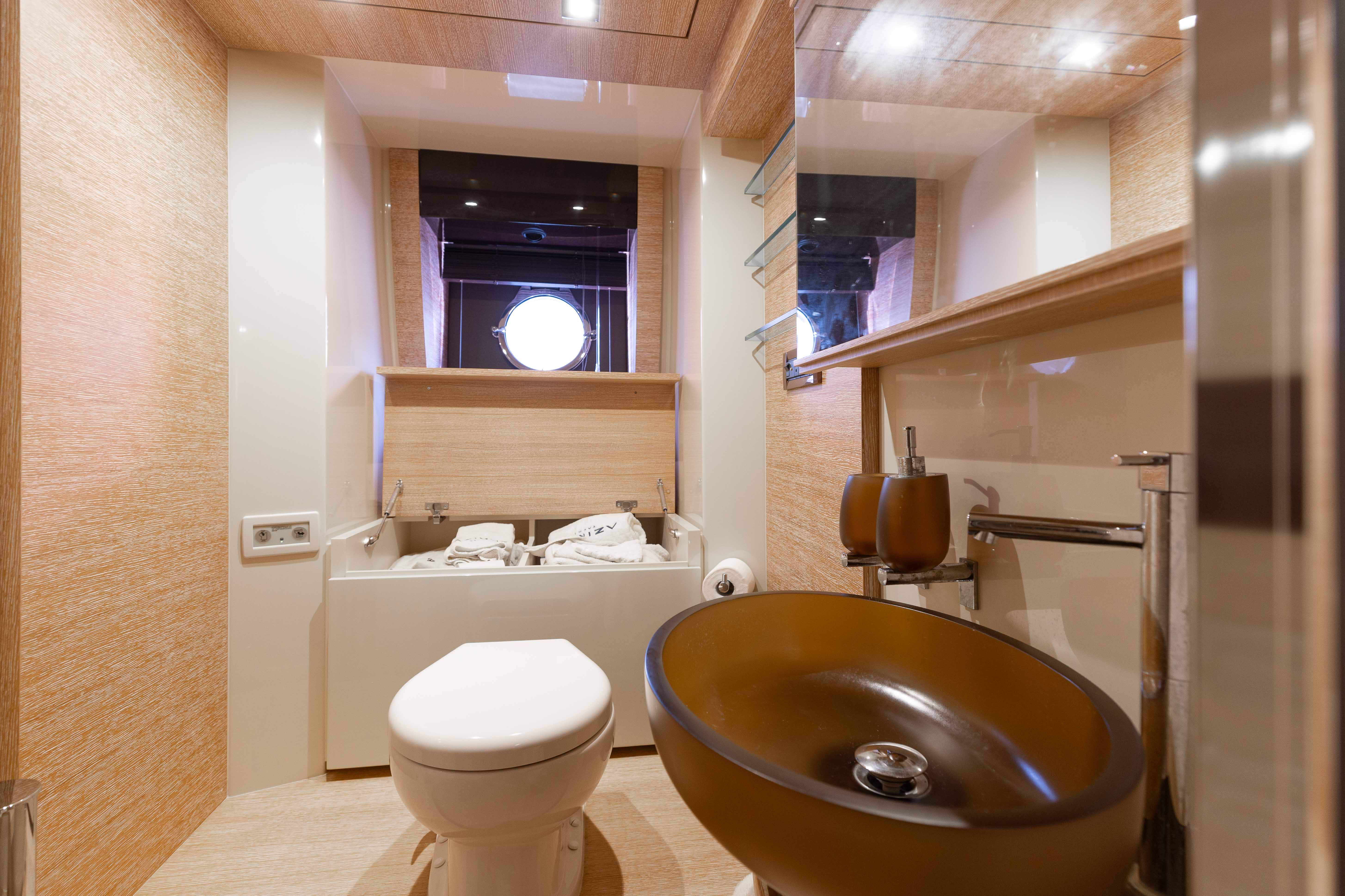 Luxurious bathroom on 2014 Azimut 60 Flybridge yacht with modern fixtures and porthole window.