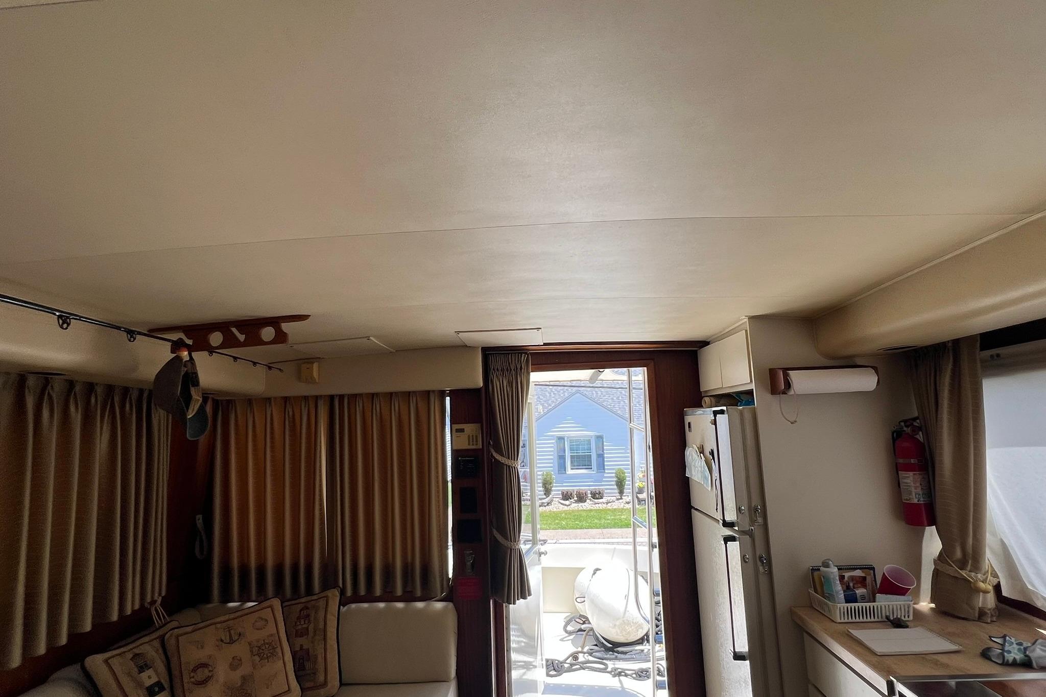 Interior of 1990 Hatteras 41 Convertible yacht with cozy seating and kitchen area.