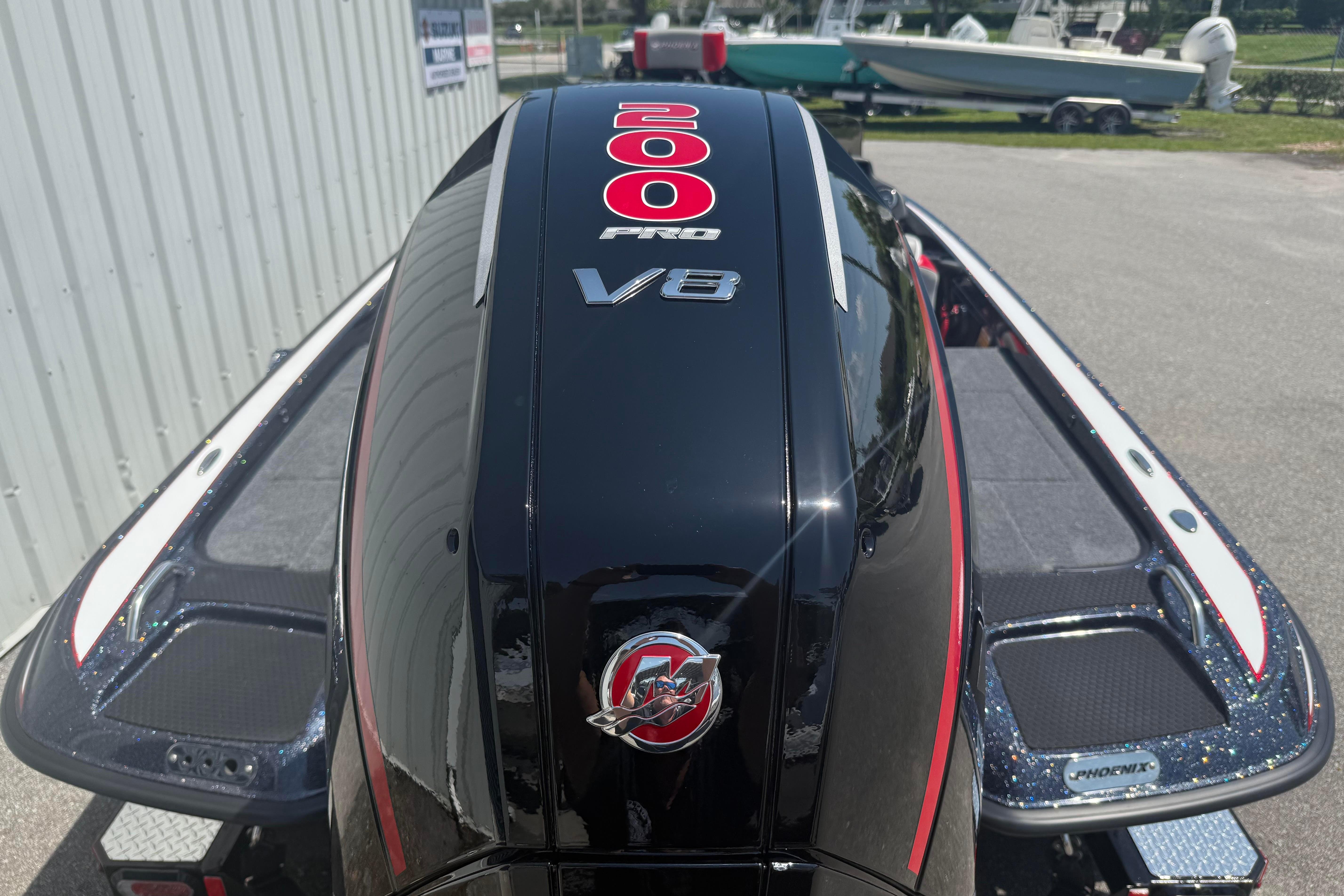 2027 Phoenix 819 ZXL boat with 200 Pro V8 engine, parked outdoors.
