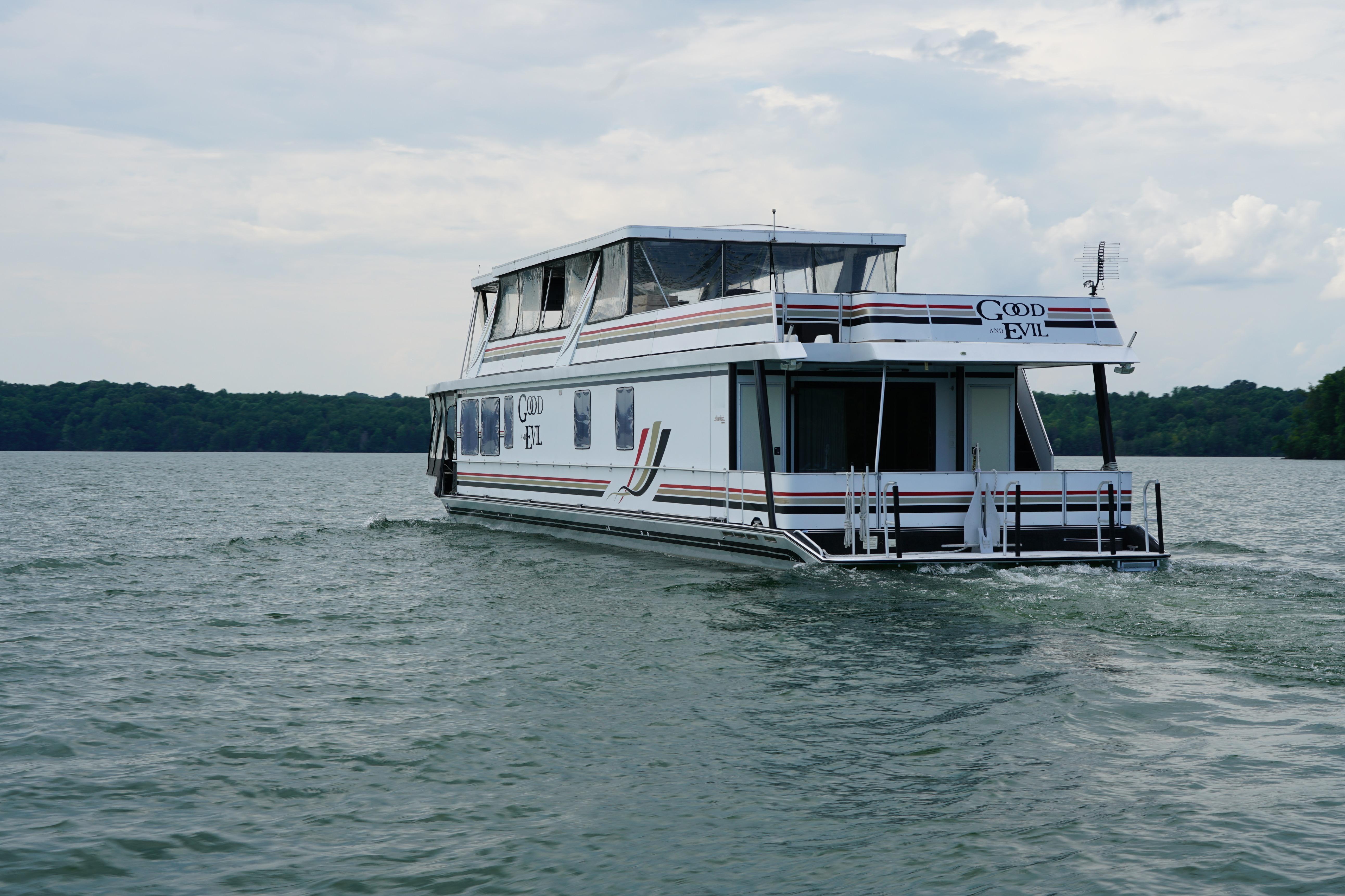 Stardust Cruisers 83'x17' houseboat from 2000 on a serene lake.
