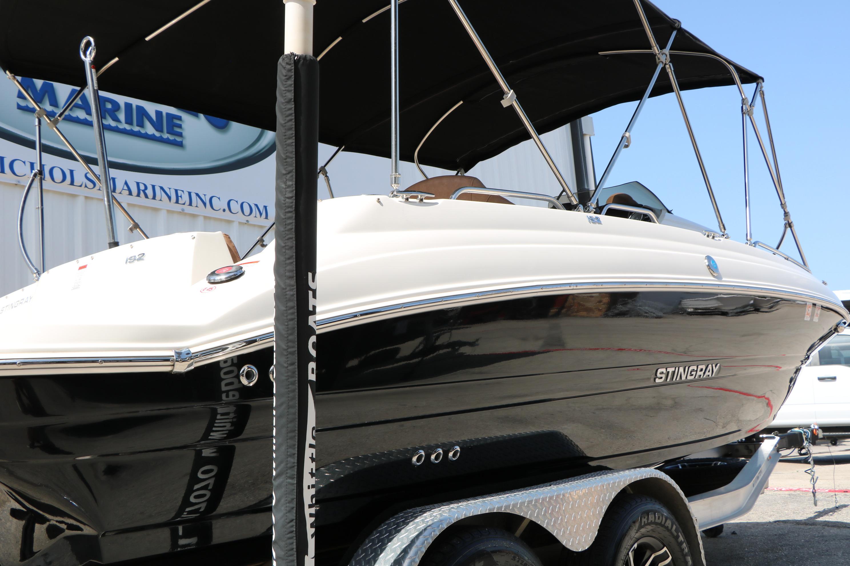 2022 Stingray 192 SC boat on trailer, featuring sleek black and white design.