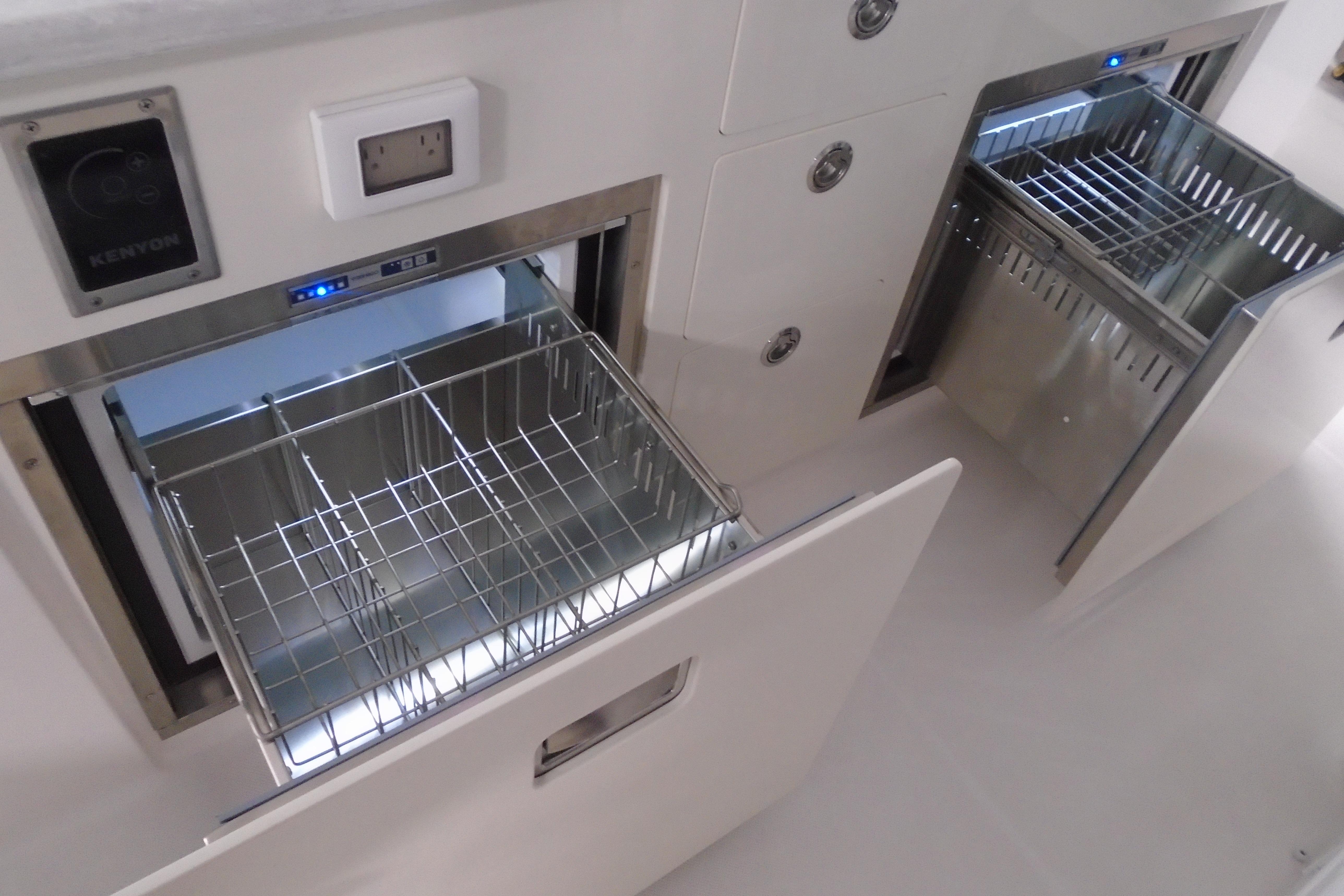 2026 Regal 38 SAV boat kitchen with open stainless steel drawers and appliances.