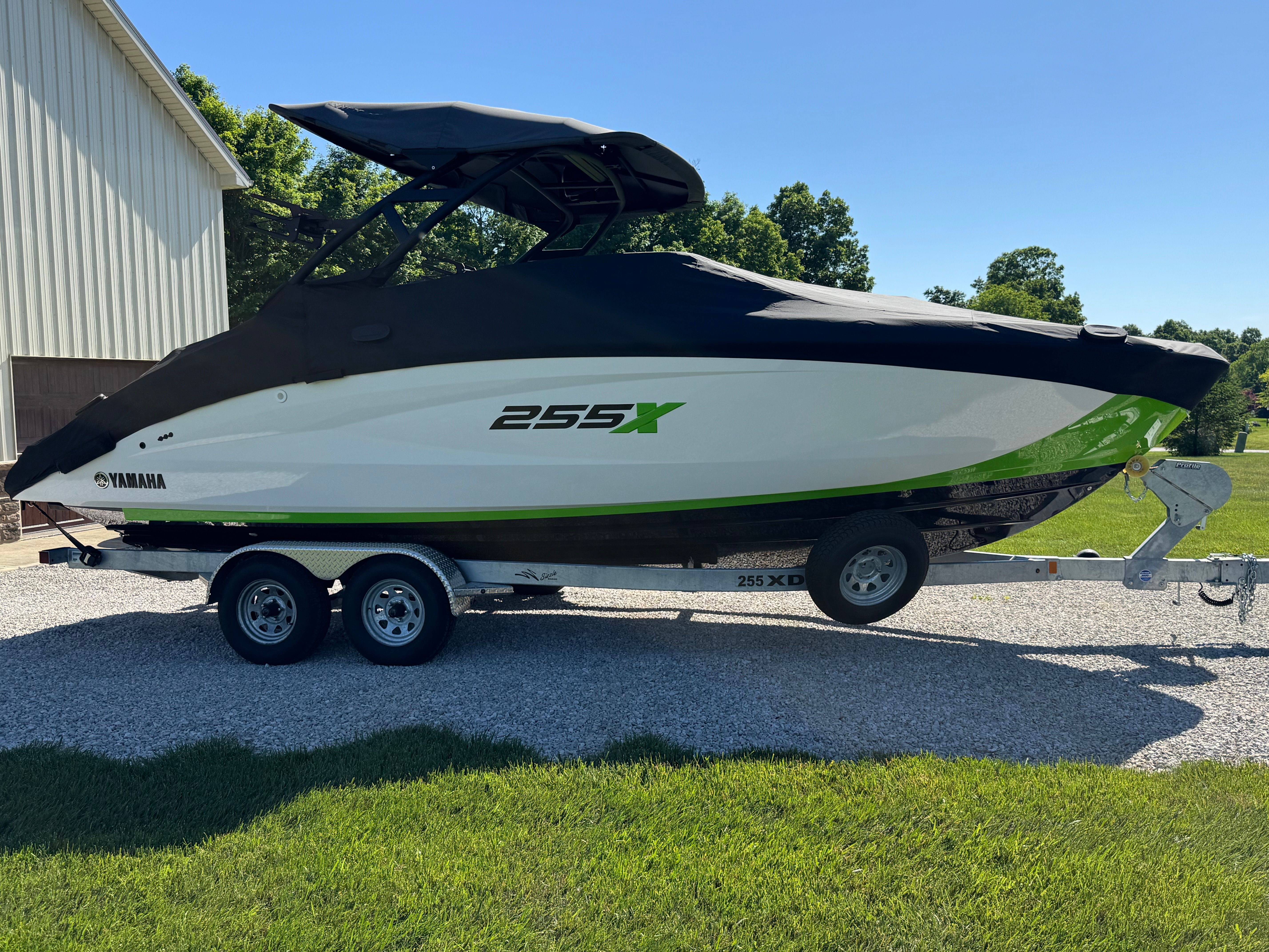 A 2022 Yamaha 255XD boat on a trailer, covered with a black cover.