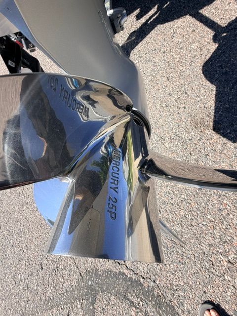 Close-up of a shiny boat propeller with "Mercury 25P" inscribed.