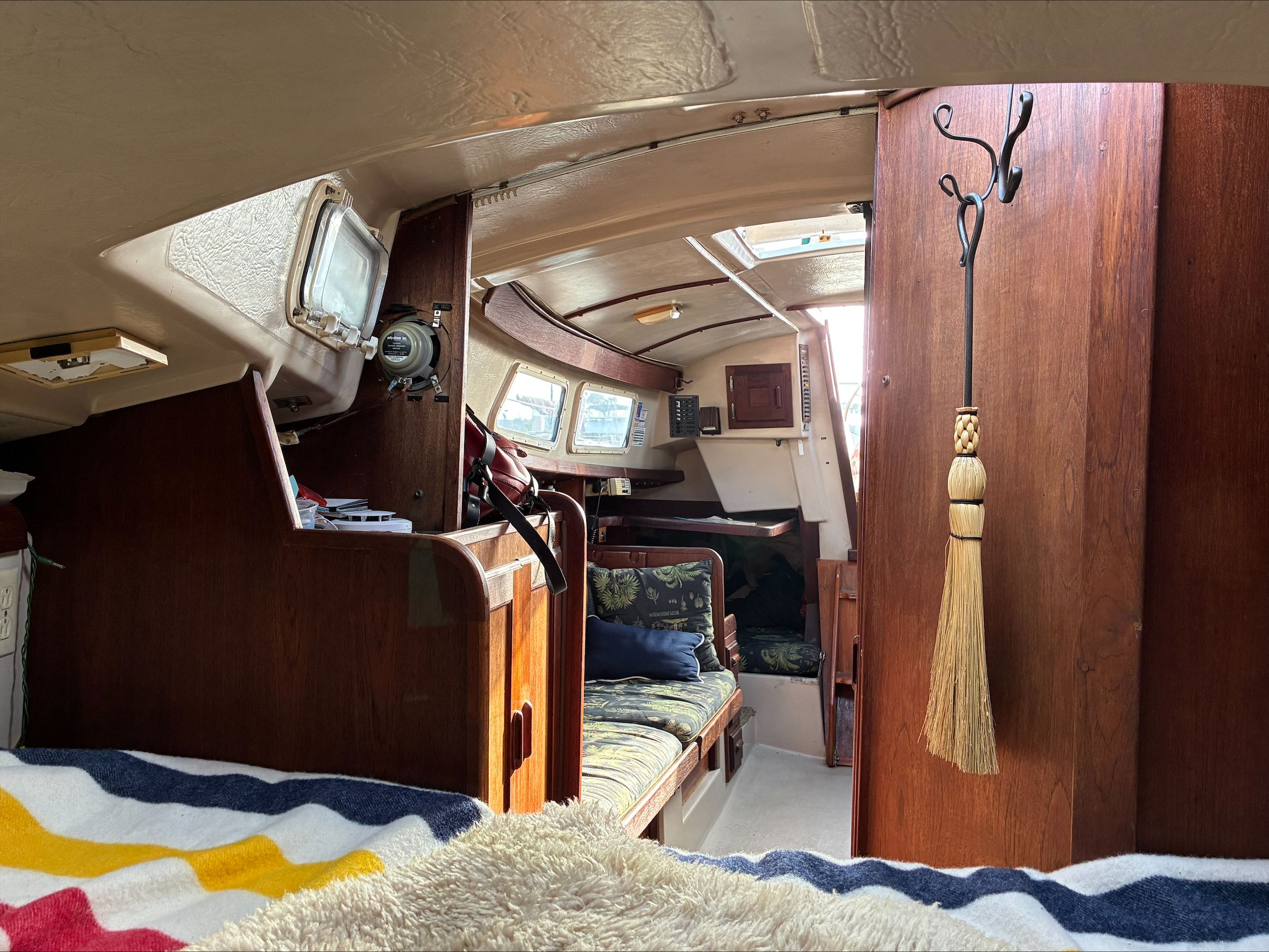 Interior view of a 1980 Newport 30 sailboat with wood paneling and cozy living area.