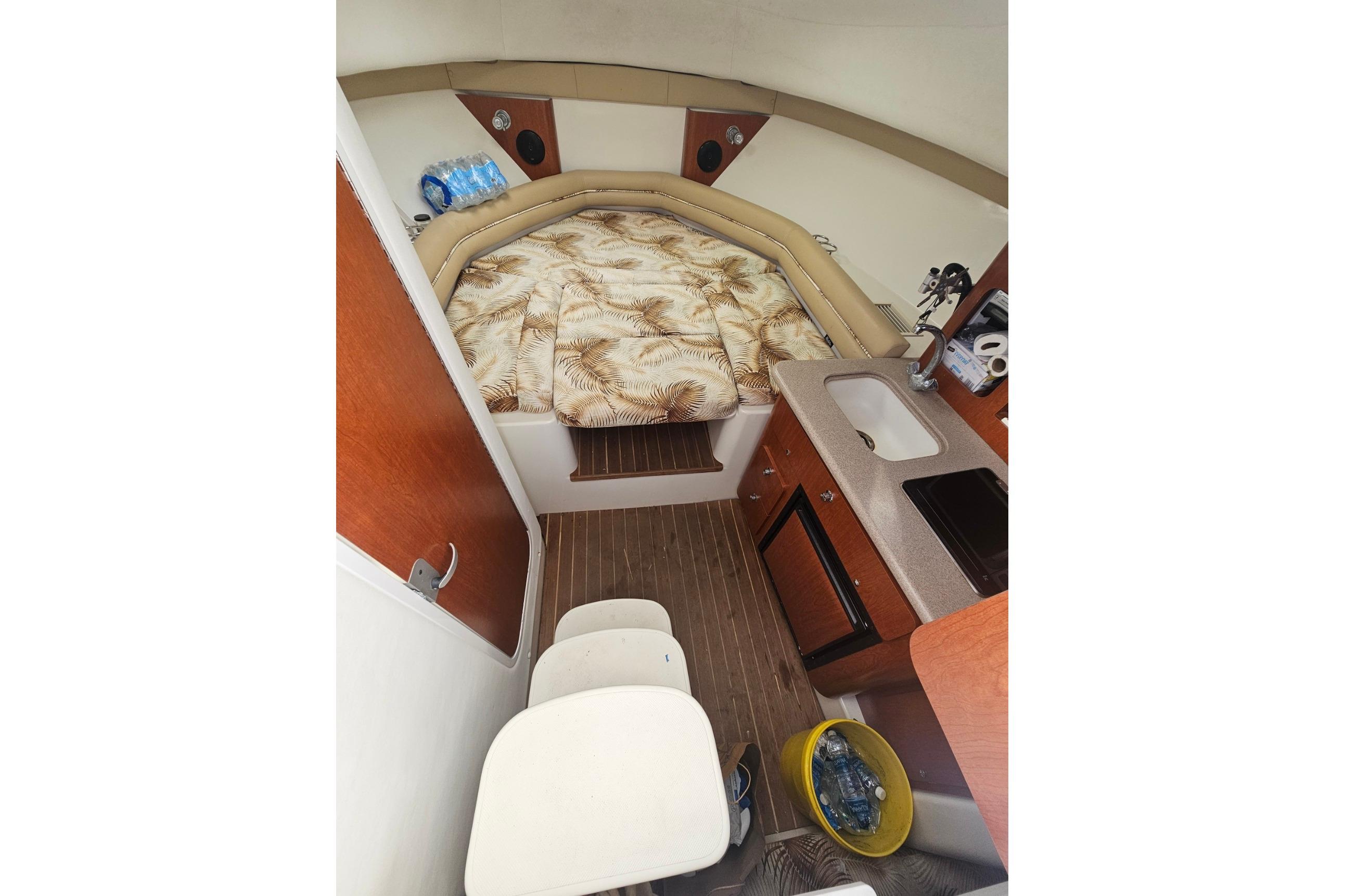 2006 Pro-Line 32 Express cabin interior with bed, kitchenette, and seating area.