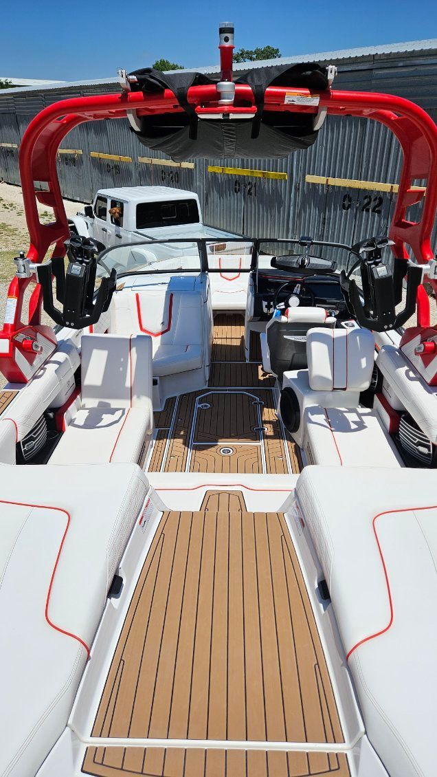 Interior of a 2018 Nautique Super Air Nautique G23 with white seats and red roll bar.