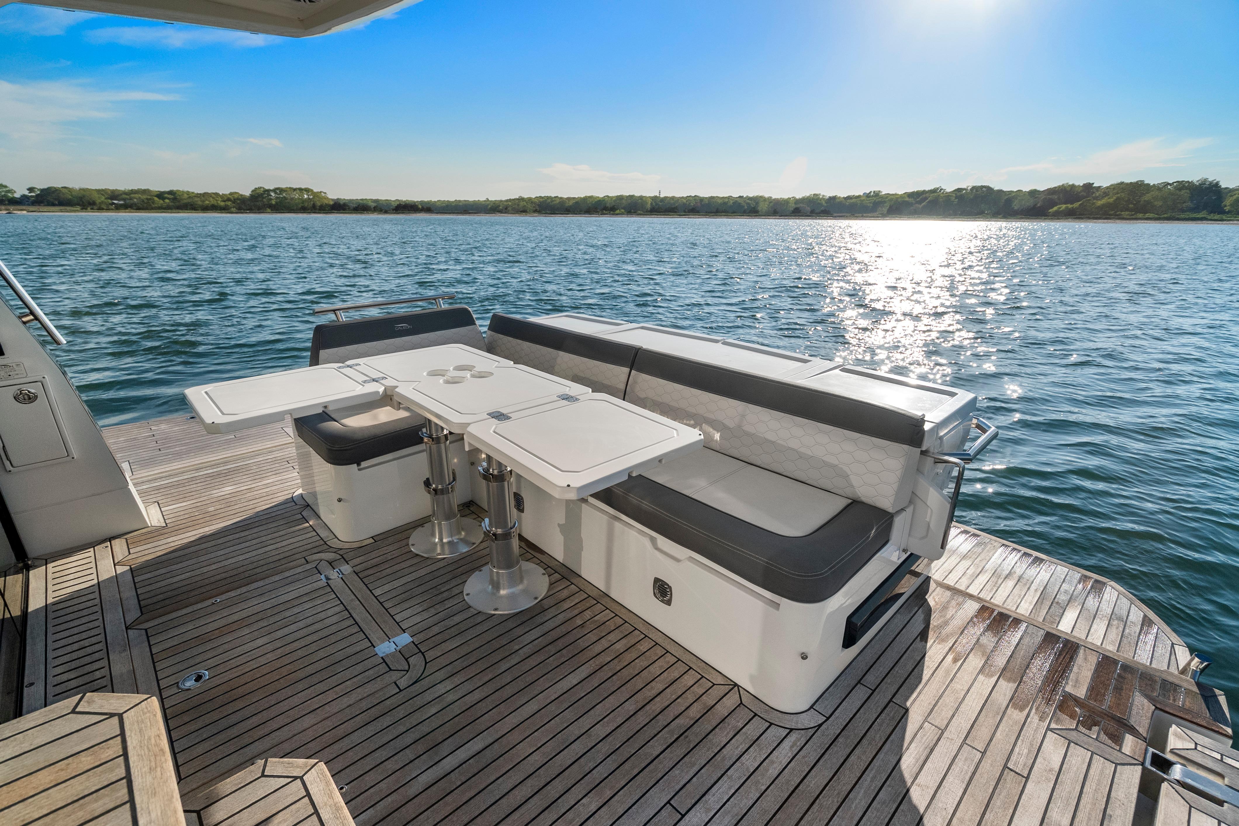 2023 Galeon 400 Fly yacht deck with seating and table, overlooking serene water.
