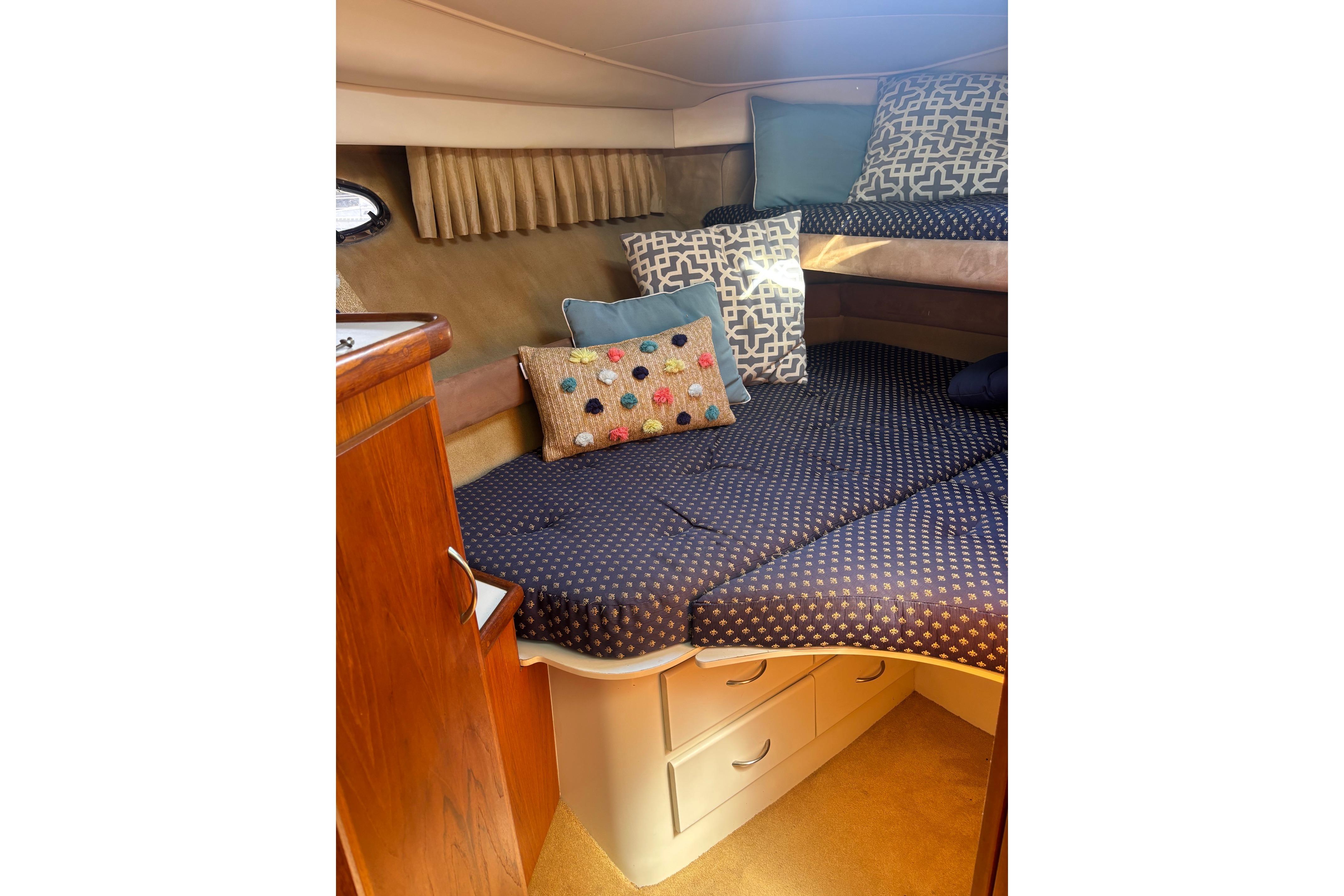 Cozy cabin interior of 1995 Carver 356 Aft Cabin Motor Yacht with patterned bedding.