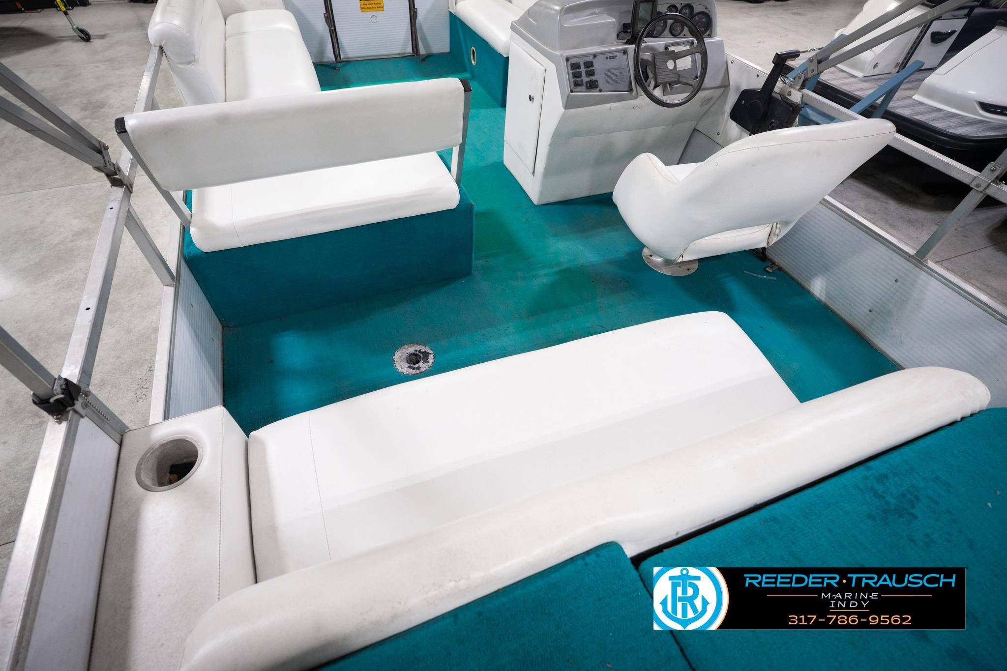 1992 Godfrey Sweetwater pontoon boat interior with white seating and teal flooring.