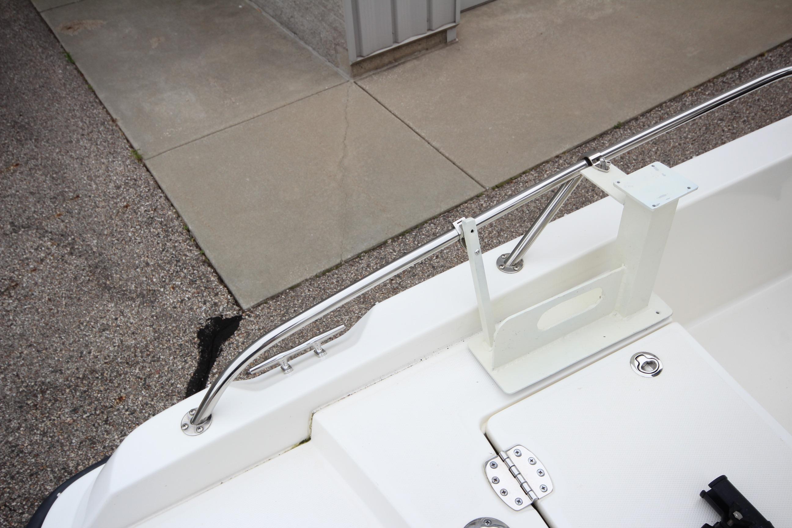 2014 Boston Whaler 210 Dauntless boat deck with stainless steel railing and storage compartment.