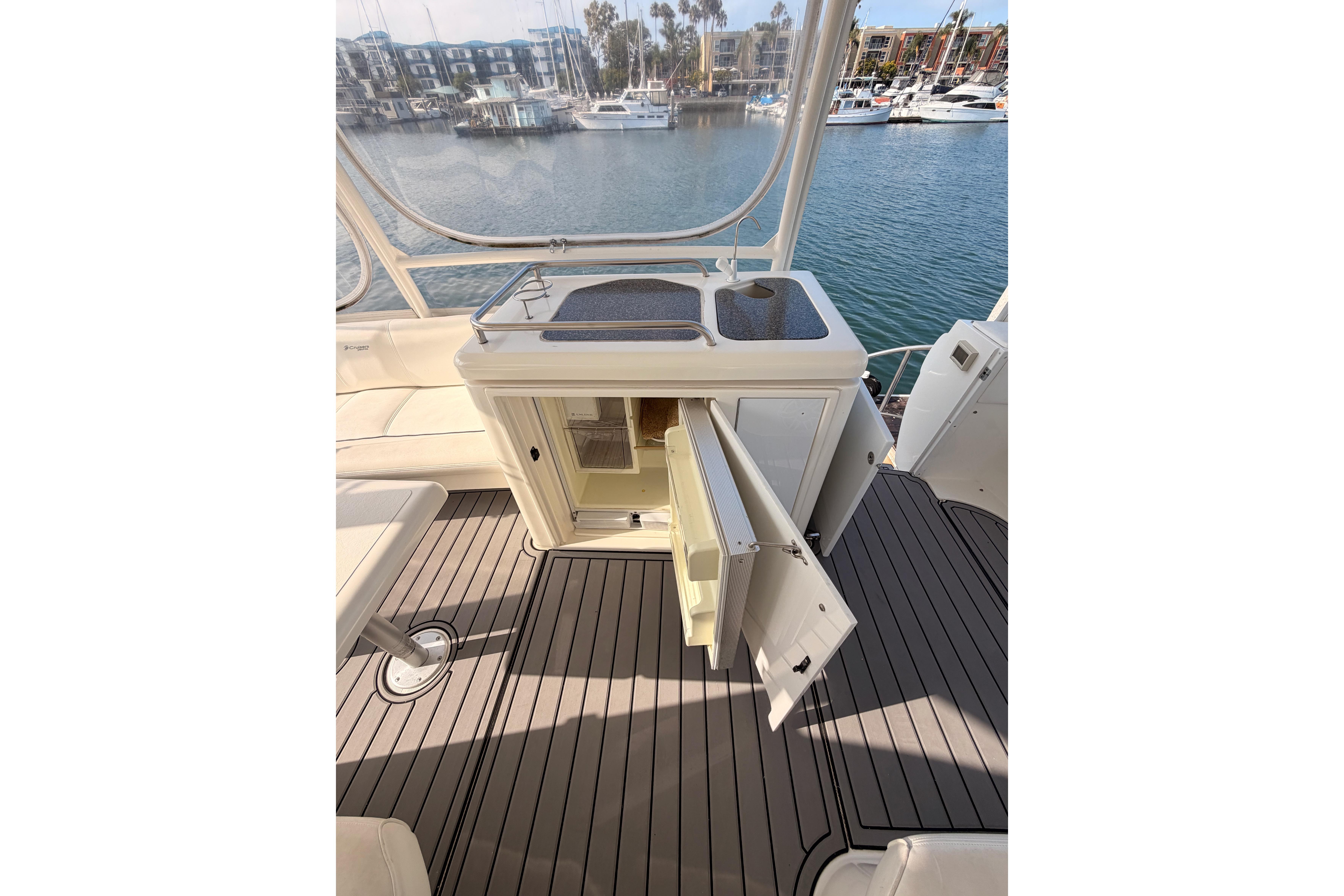 2005 Cruisers Yachts 405 Express Motoryacht interior with open cabinet and marina view.