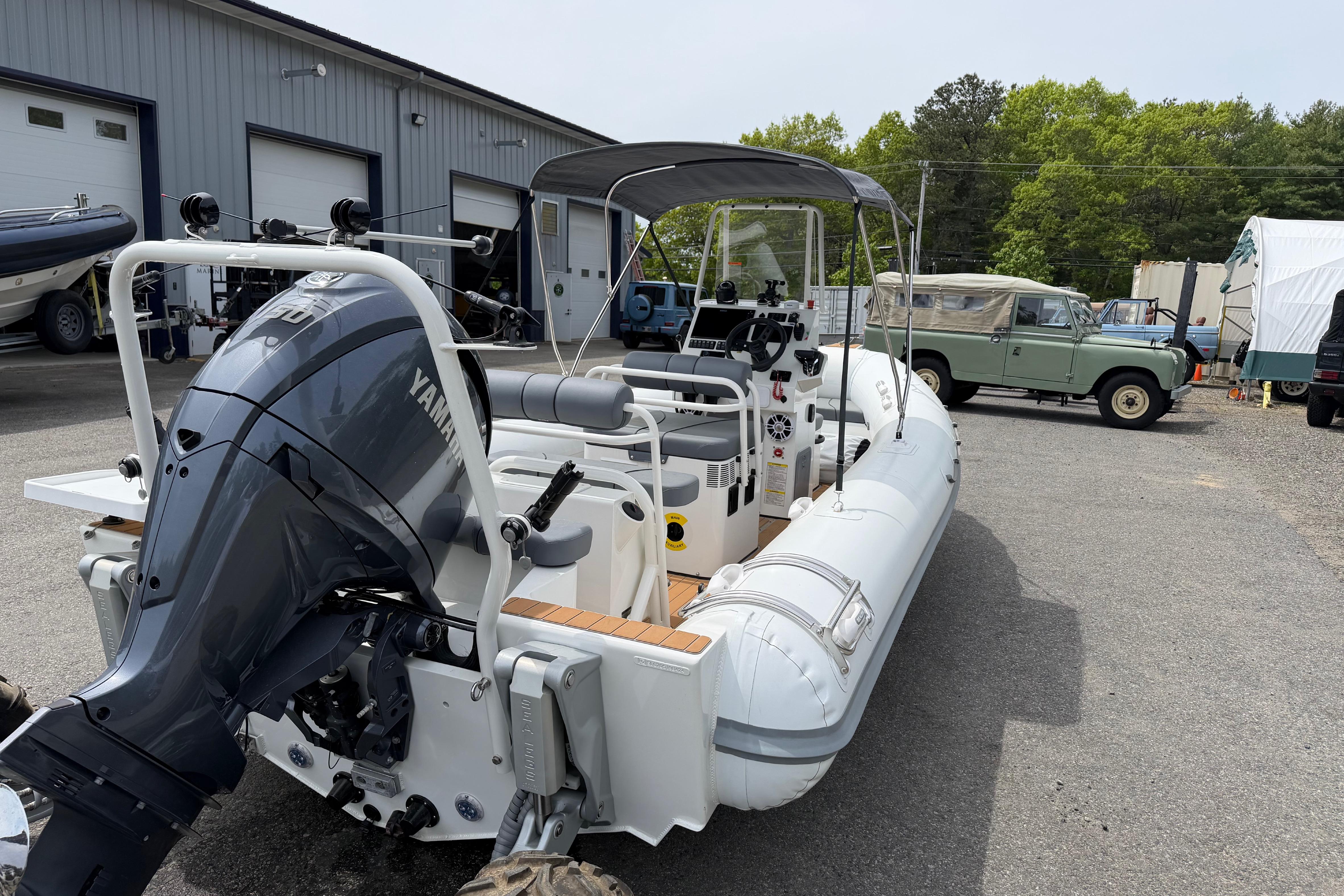 2024 Sealegs 7.1m RIB with Yamaha engine, parked outdoors near a garage.