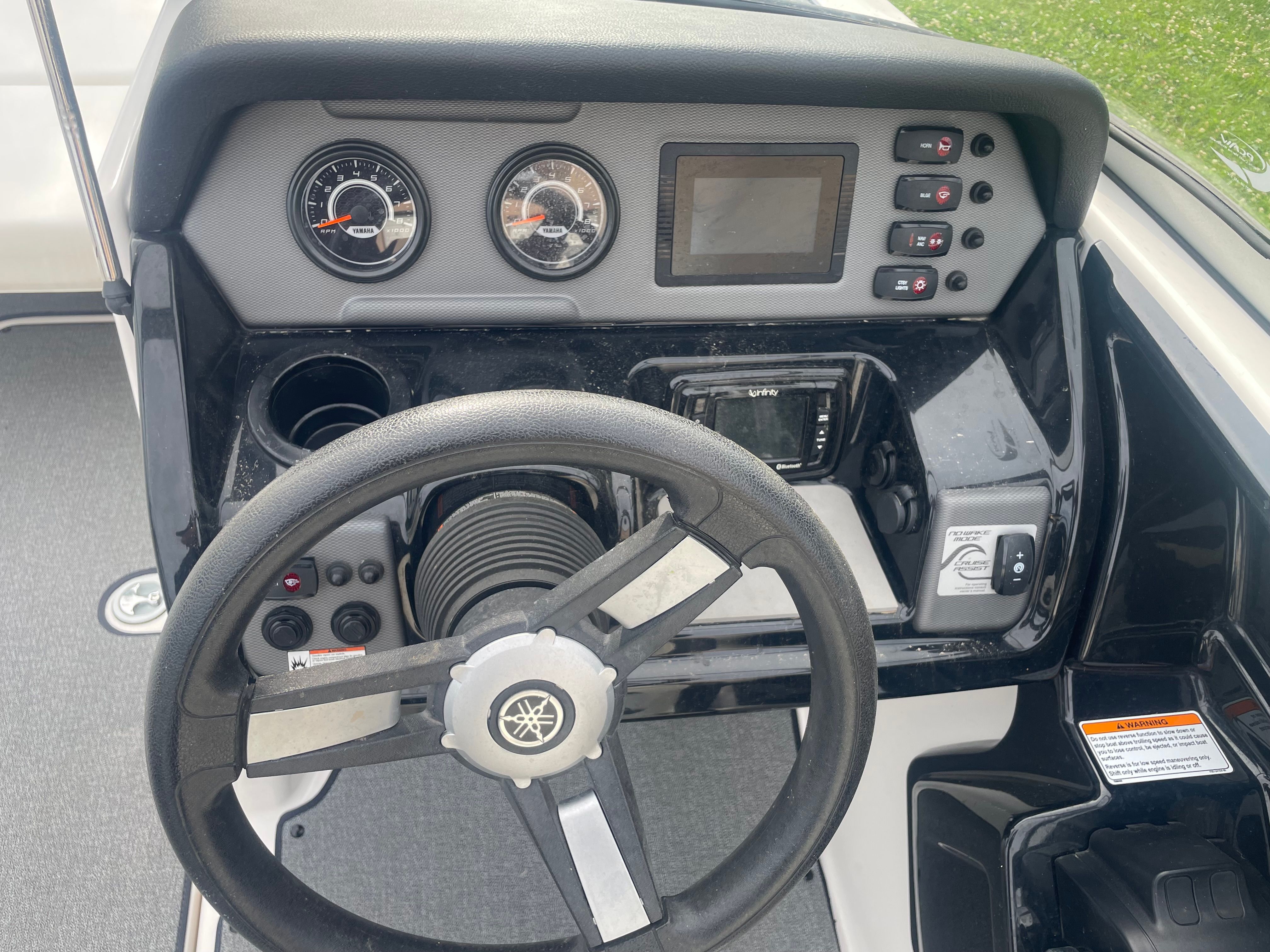 The image shows the dashboard of a 2019 Yamaha SX210 boat with steering wheel and instruments.