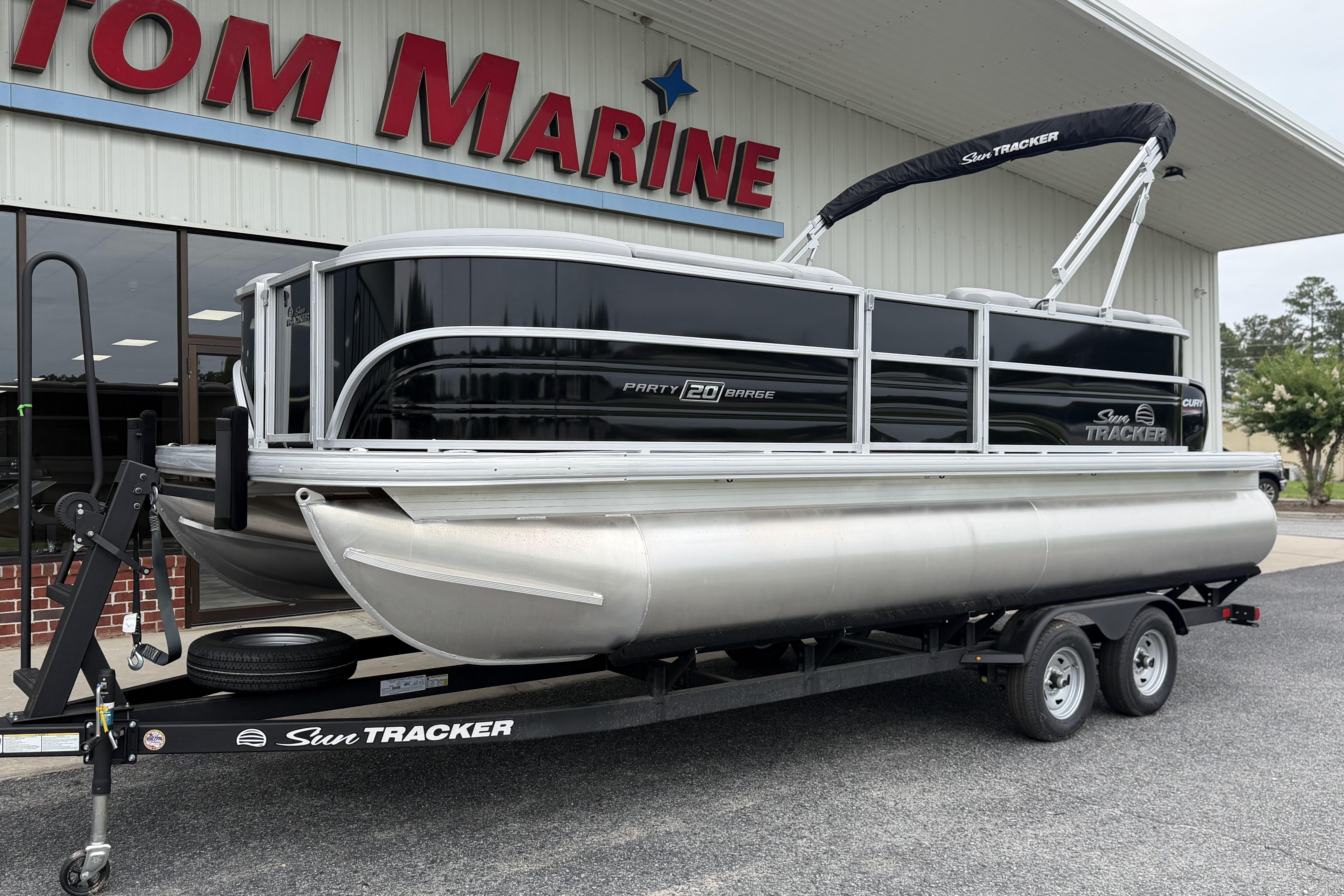 2026 Sun Tracker Party Barge 20 DLX pontoon boat on trailer outside dealership.