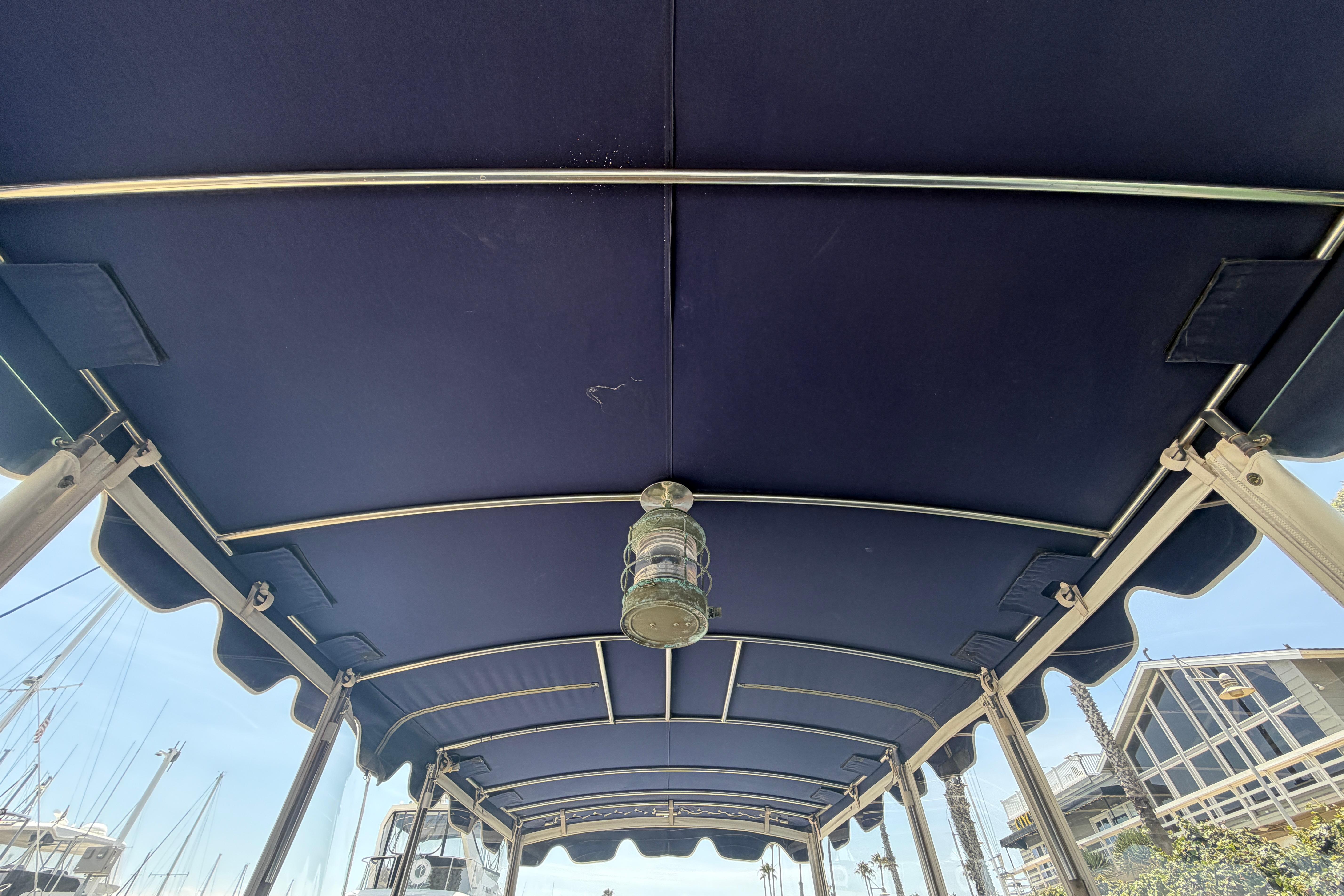 Blue canopy of a 1996 Duffy Classic 21 boat with metal frame and light fixture.