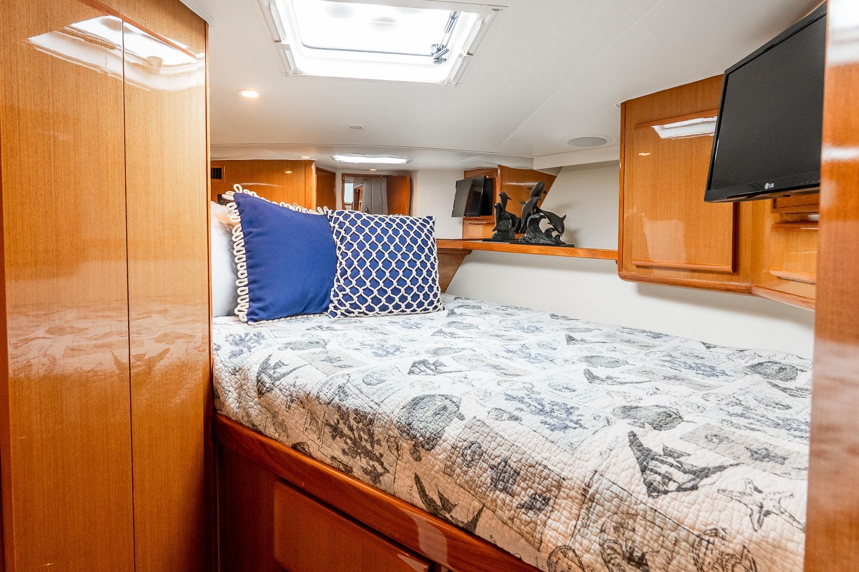 Luxurious cabin interior of 2000 Viking 50' Convertible yacht with cozy bedding.