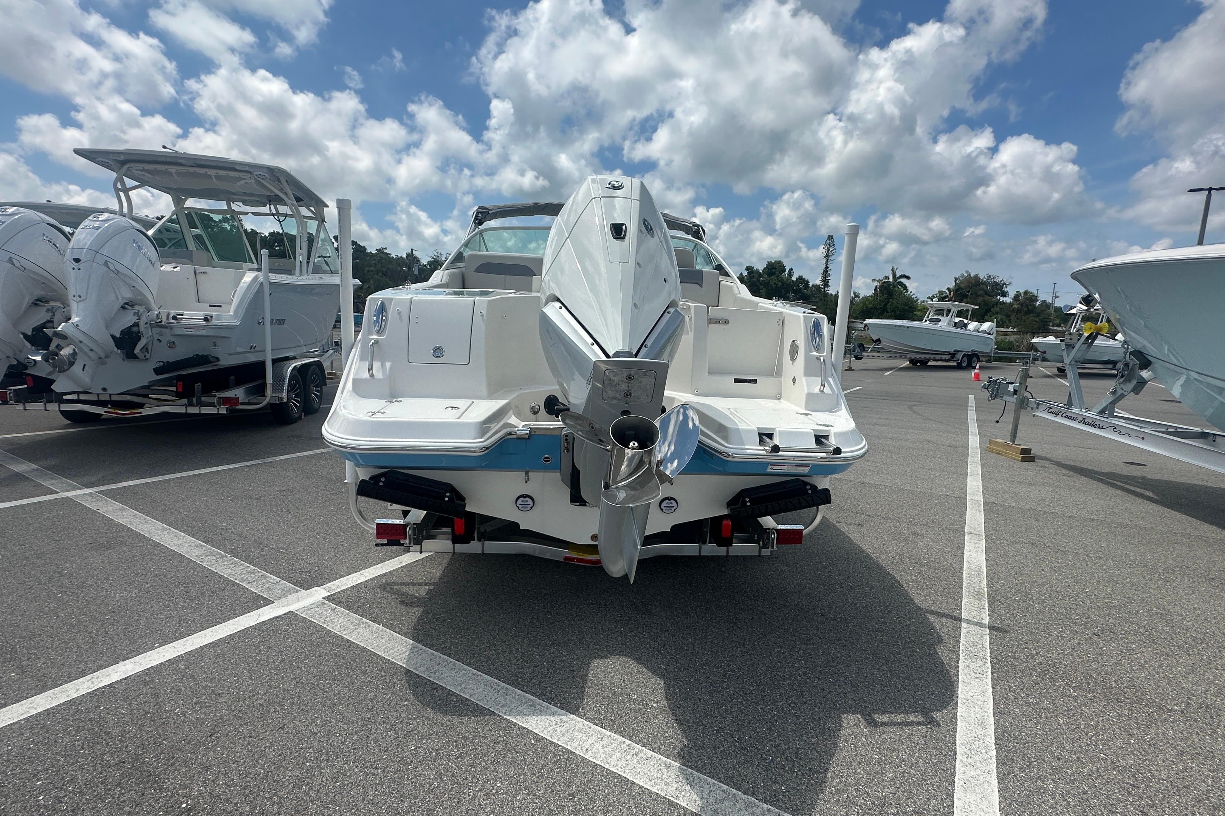 2026 Sailfish 226 DC boat in parking lot, rear view under cloudy sky.