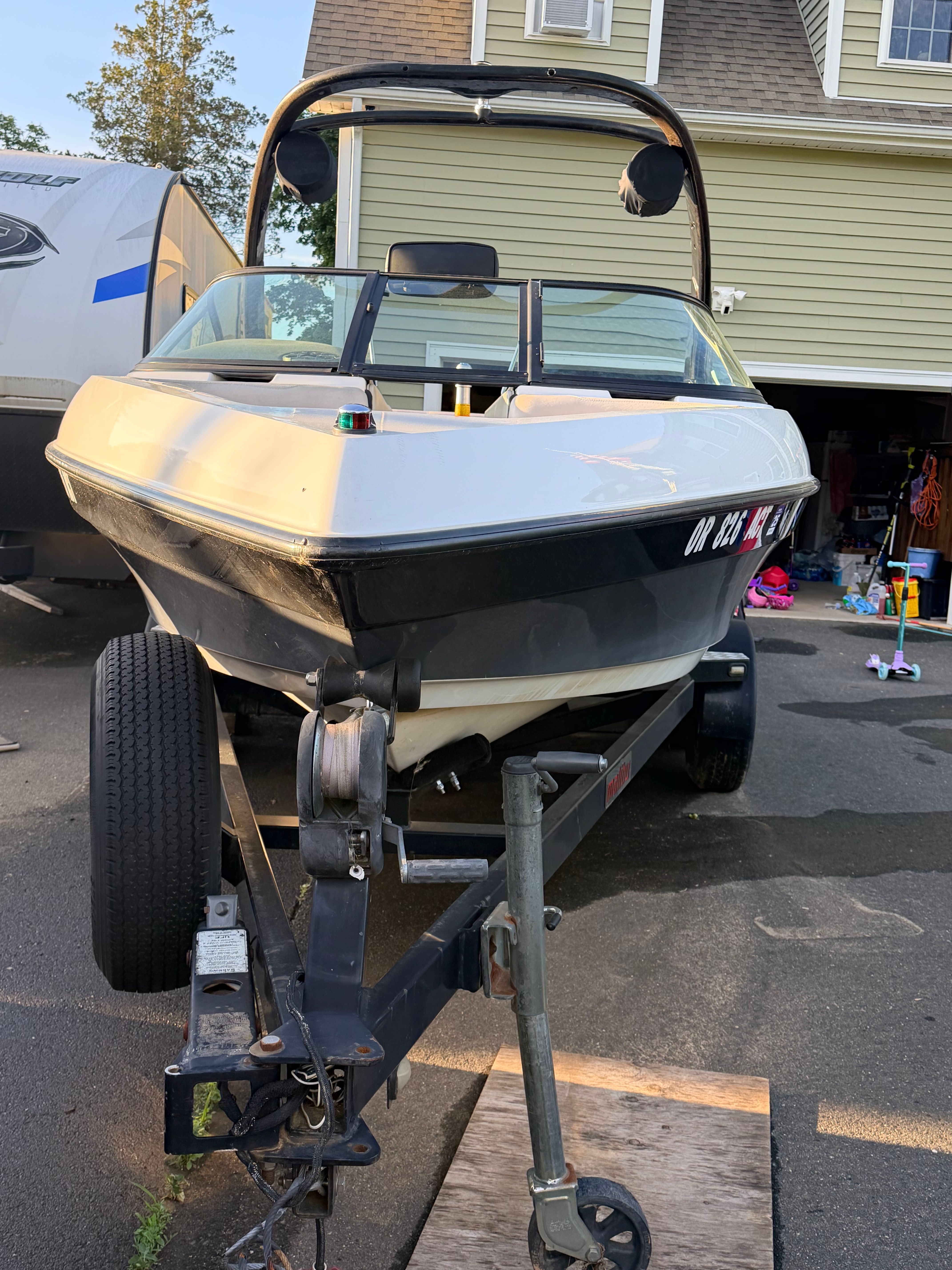 2006 Malibu iRide boat on trailer in driveway.