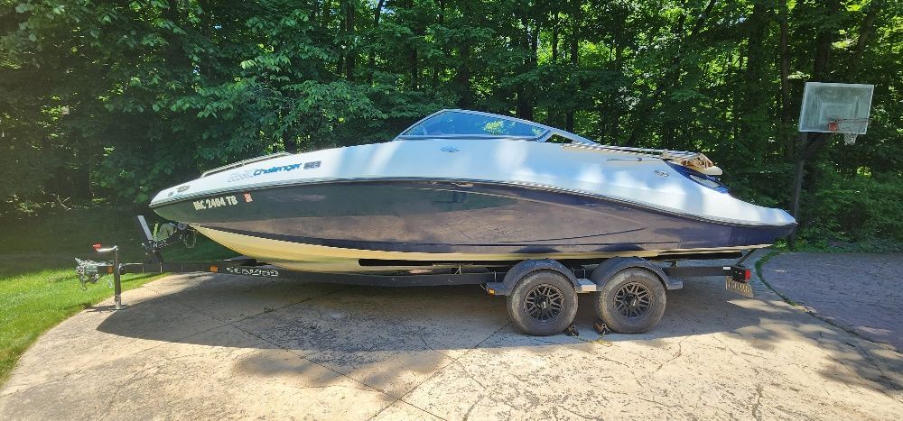 A 2007 Sea-Doo Sport Boat 230 Challenger SE on a trailer, surrounded by trees.
