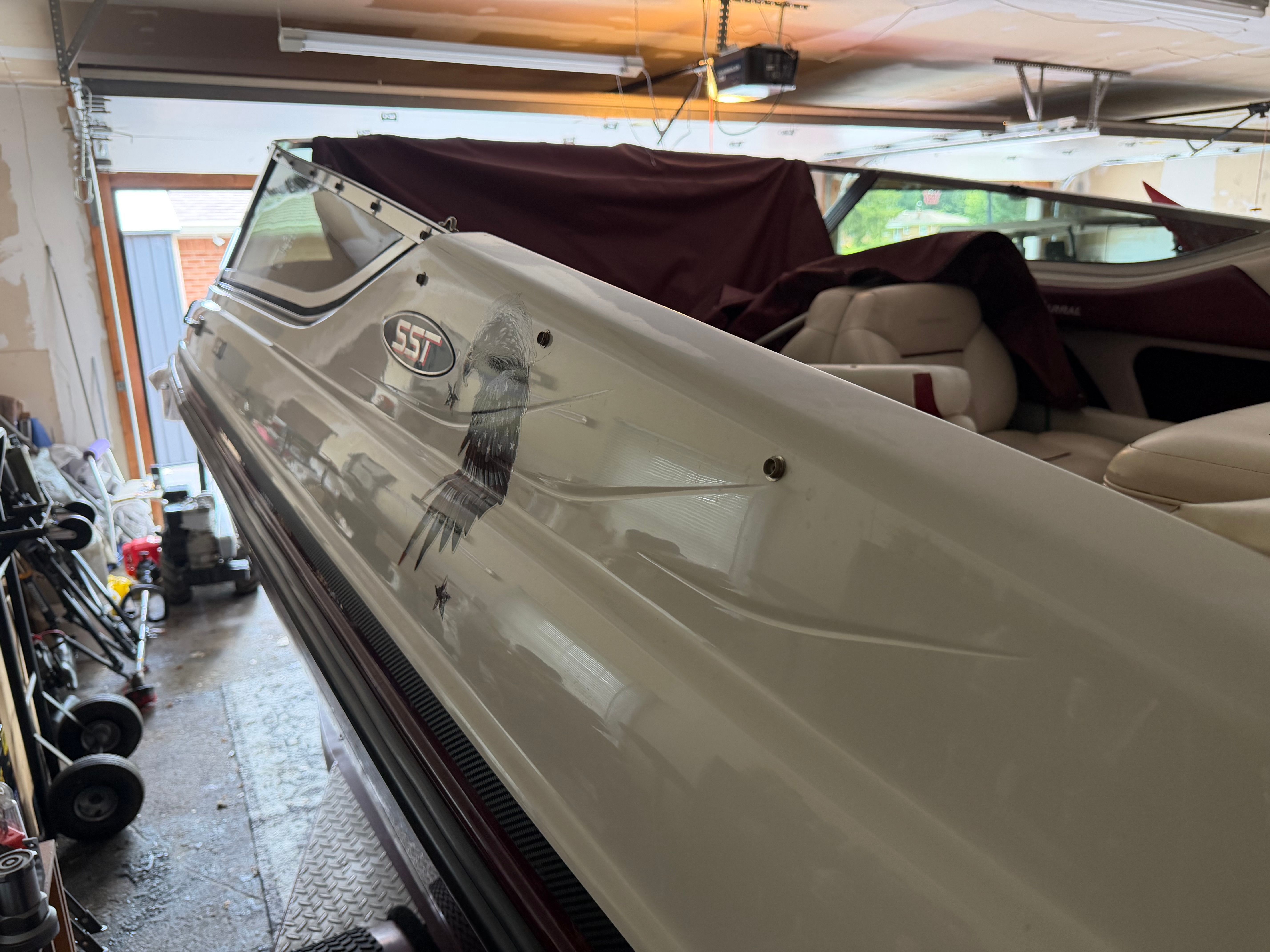 A 1994 Chaparral 1930 boat in a garage. It features a white exterior with an eagle design.