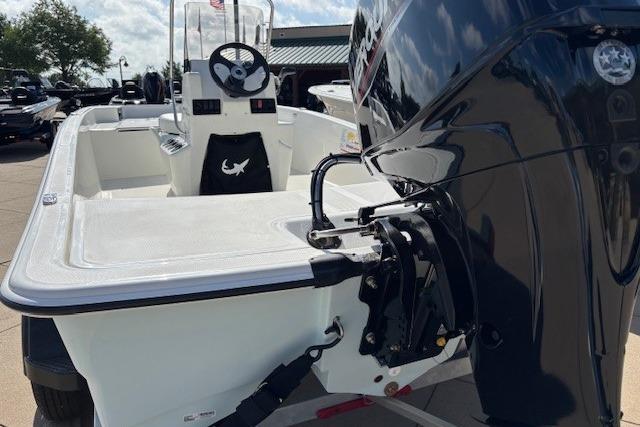 2026 Mako Pro Skiff 15 CC boat with outboard motor, docked under sunny skies.