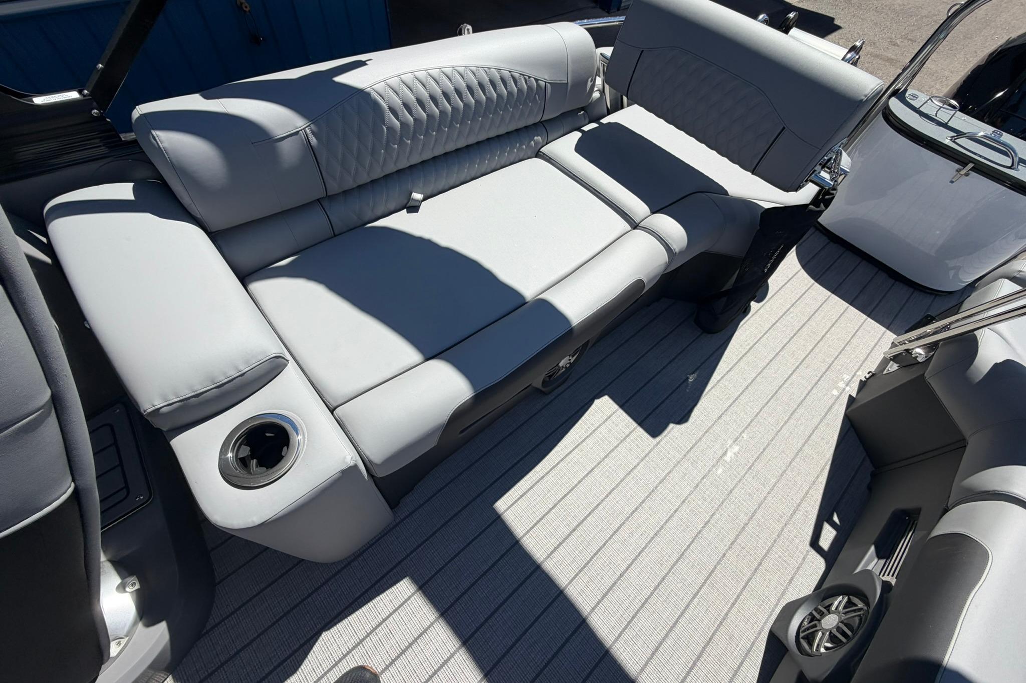 2026 Avalon Catalina Quad Lounge Shift boat interior with gray seating and cup holder.