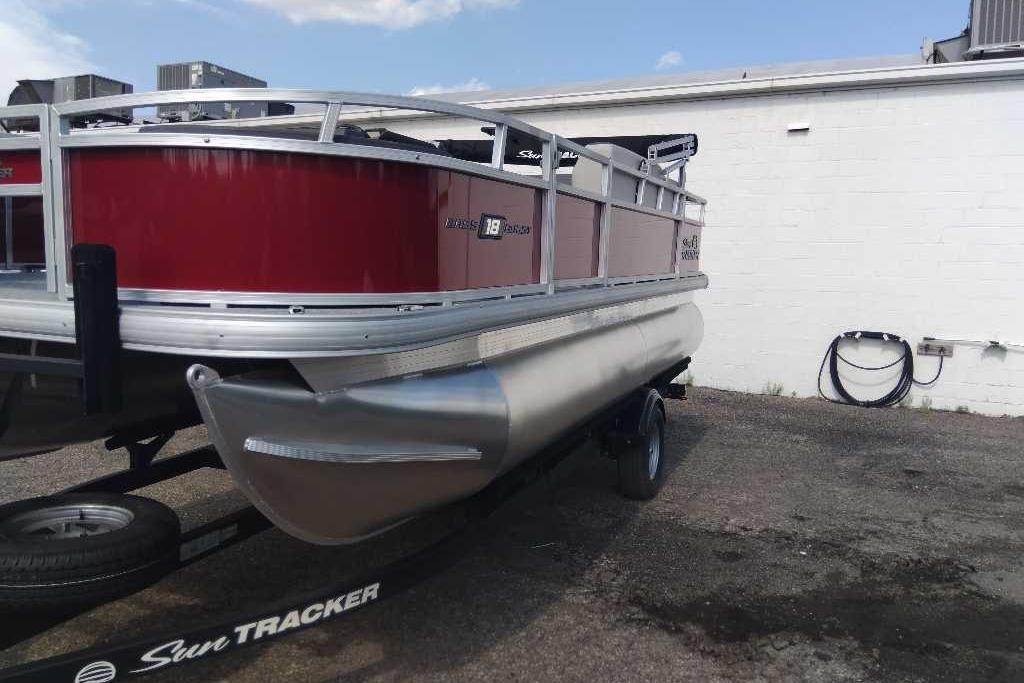 2026 Sun Tracker Bass Buggy 18 DLX pontoon boat on trailer, red and silver design.