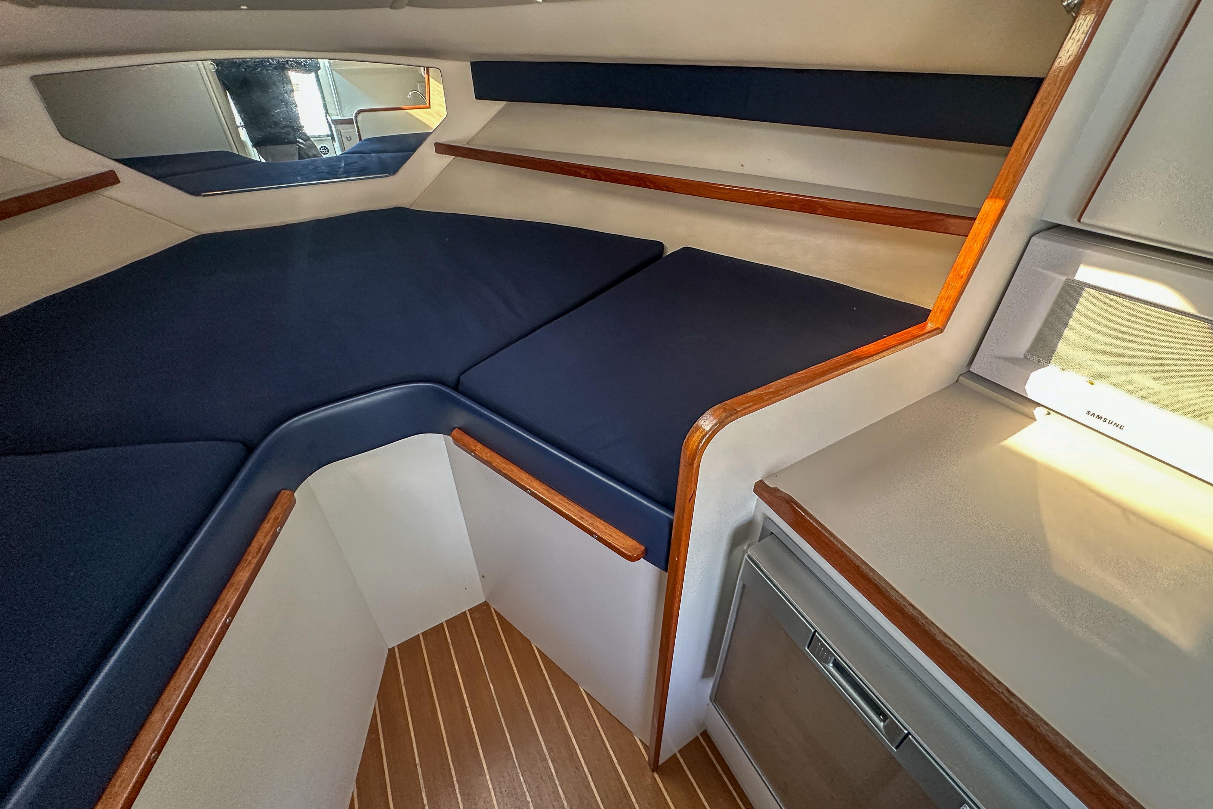 2001 Tiara Yachts 2900 Coronet cabin interior with blue cushions and wood accents.