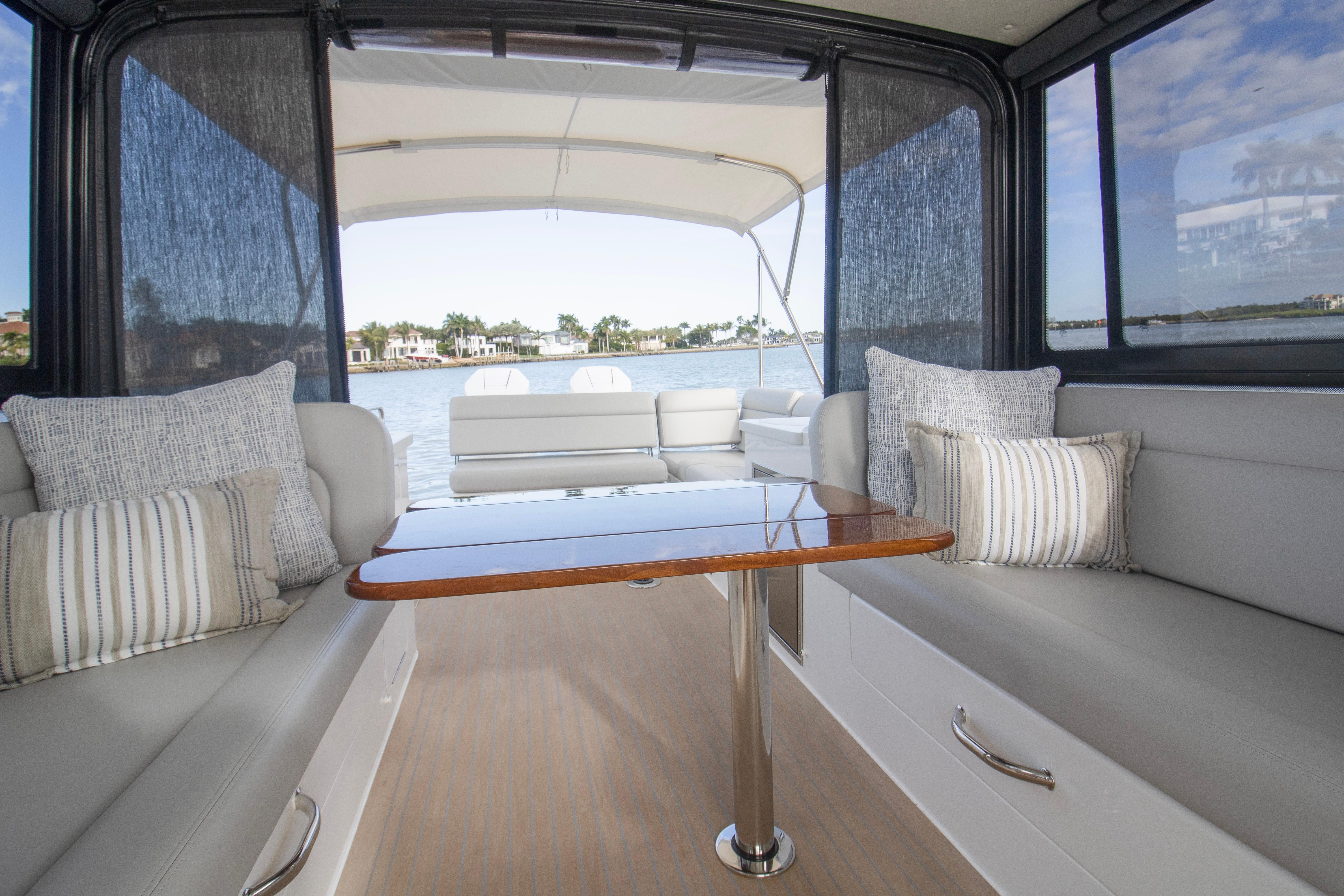 Luxurious interior of 2025 MJM 38 X yacht with elegant seating and scenic water view.