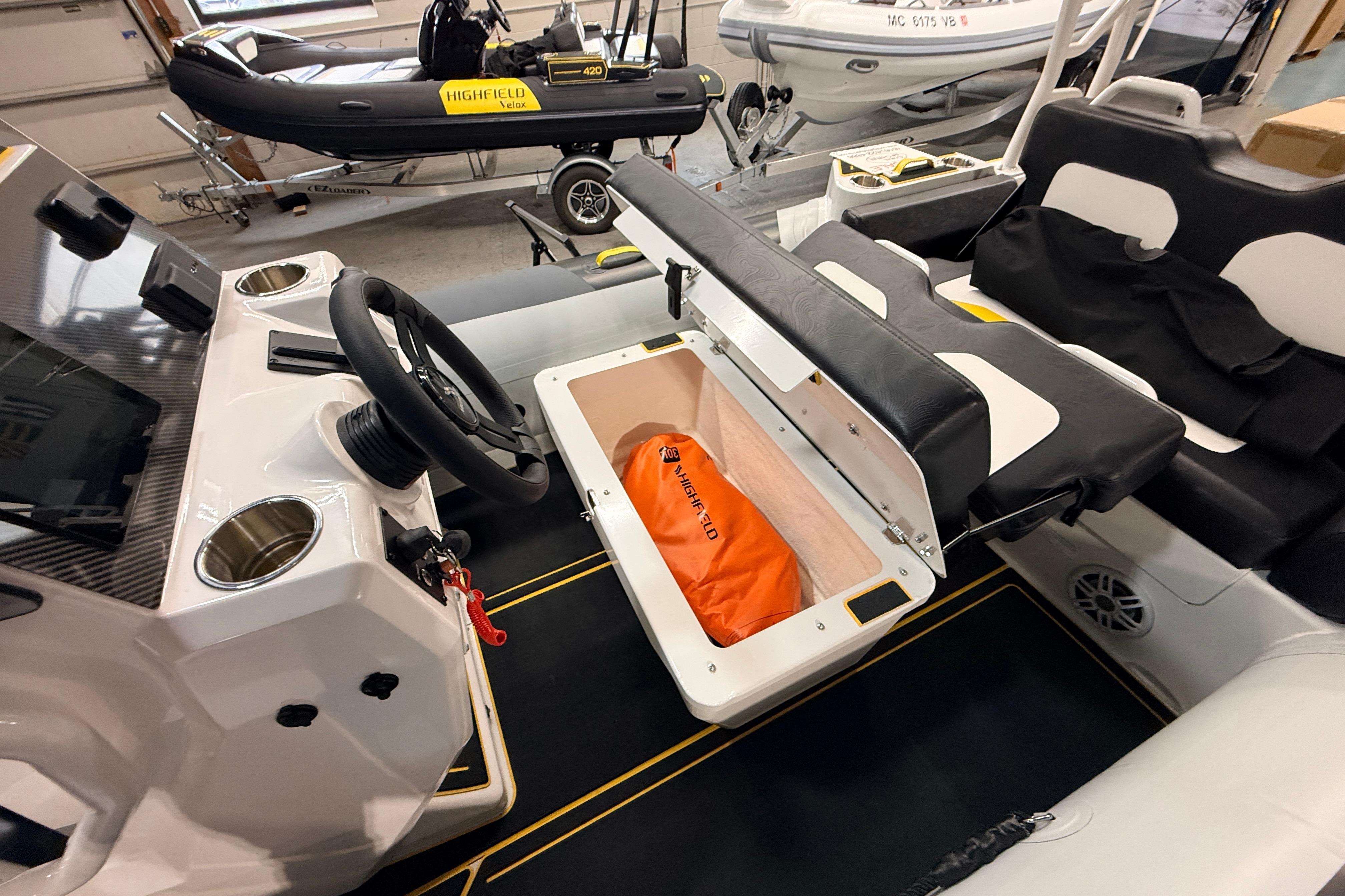 2026 Highfield VELOX 560 boat interior with storage compartment and steering wheel.