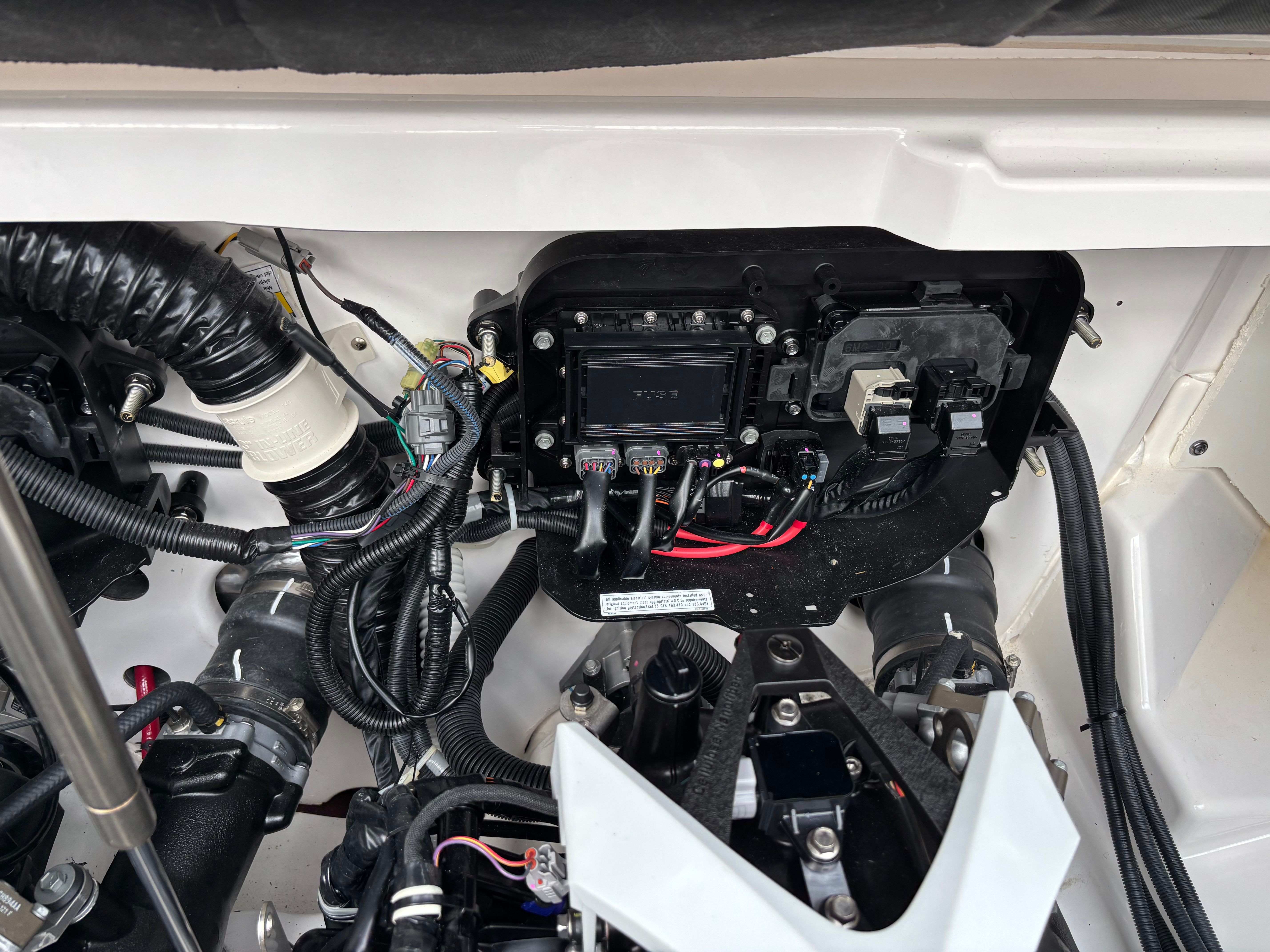 Close-up of a Yamaha AR250 boat's engine compartment with wires and components.