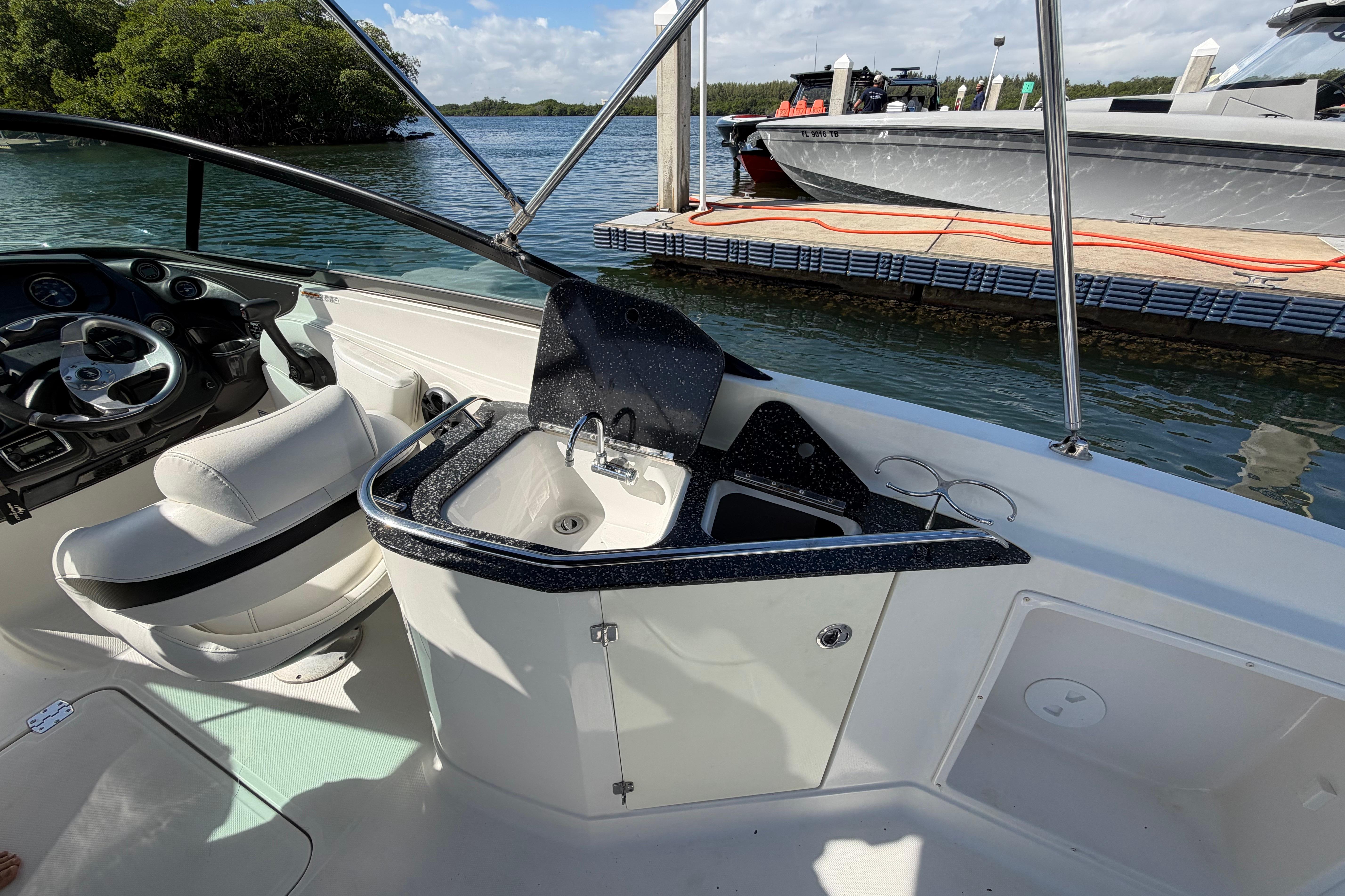 2015 Monterey 264FS boat interior with steering wheel and sink, docked by the water.